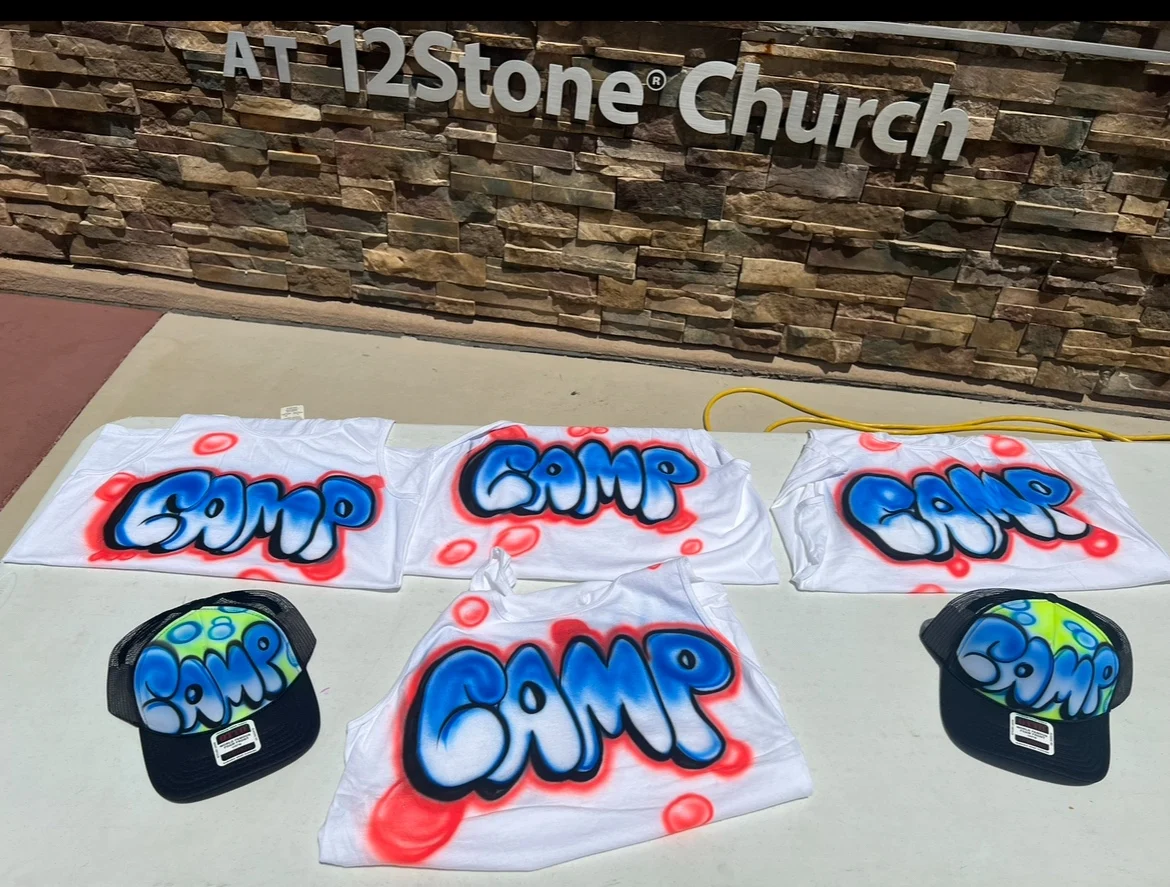 Custom camp shirts and hats displayed at 12Stone Church
