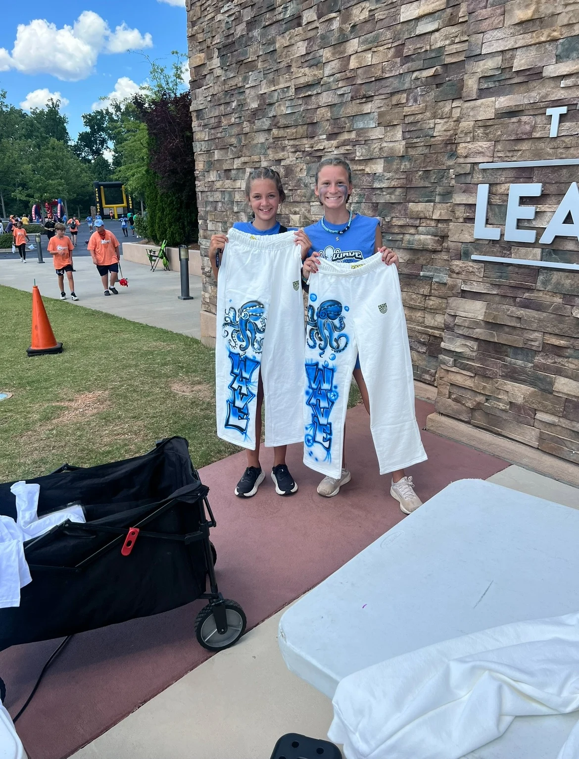Guests holding long white items with blue airbrushed designs