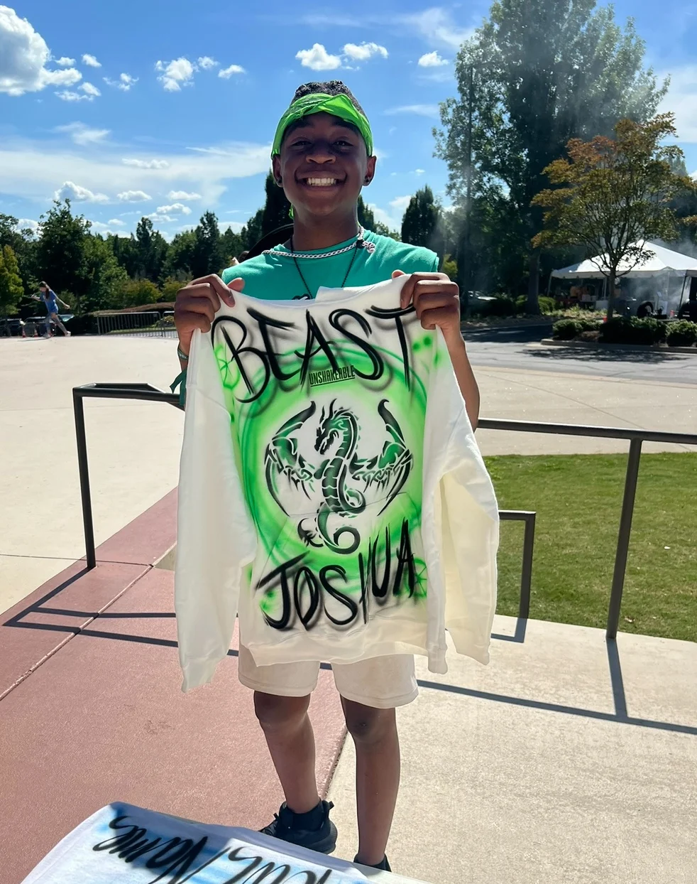 Guest holding a shirt with a green Jesus design