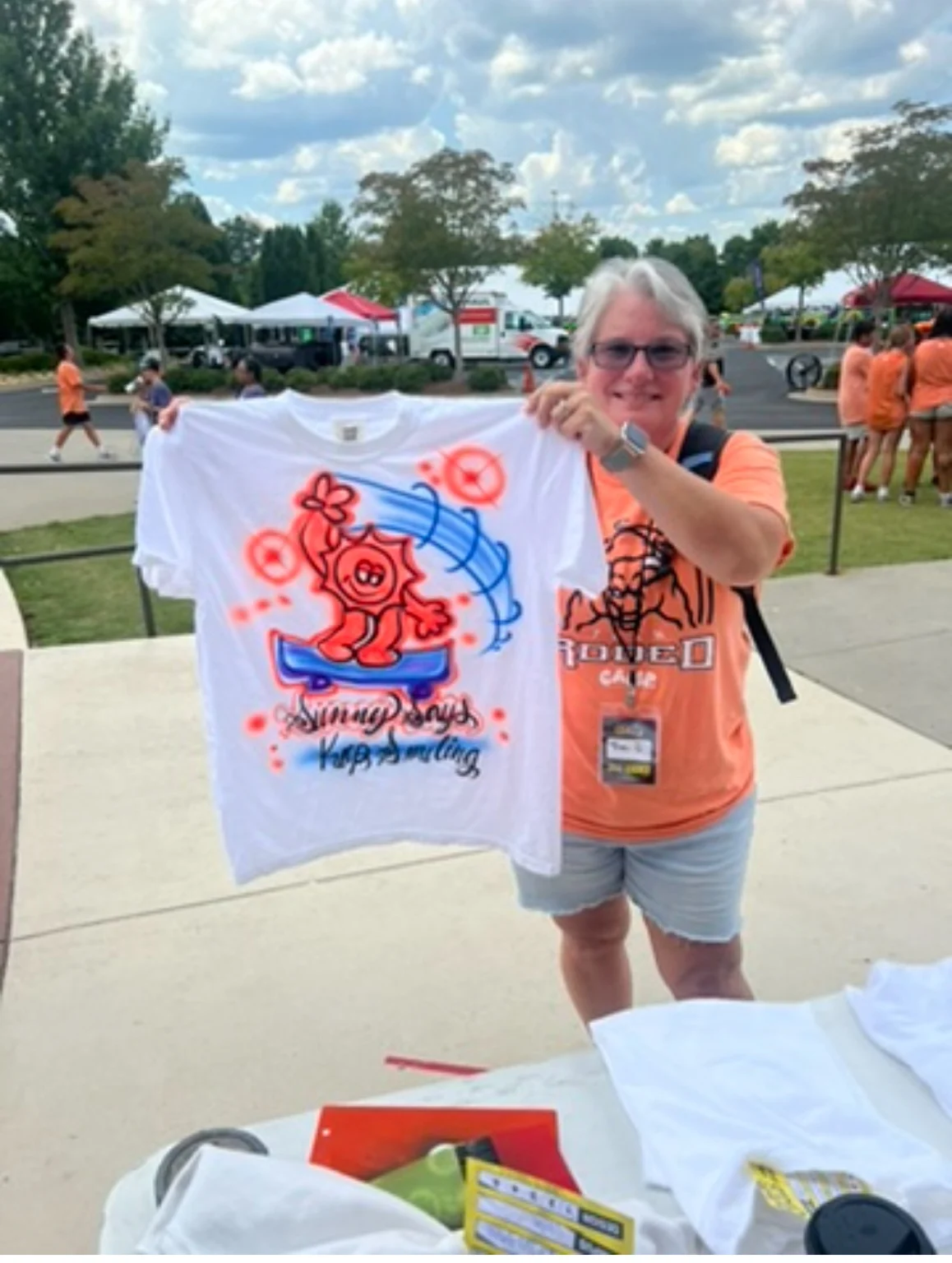 Guest holding a shirt with a colorful Jesus design