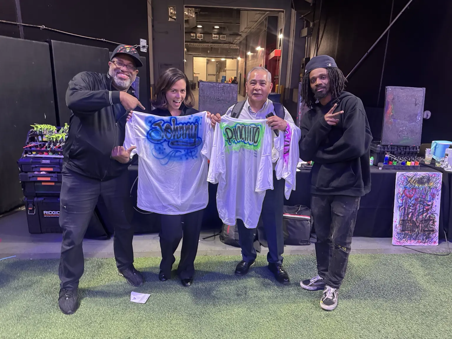 Guests and 3JS artists displaying personalized football jerseys at Mercedes-Benz Stadium in Atlanta