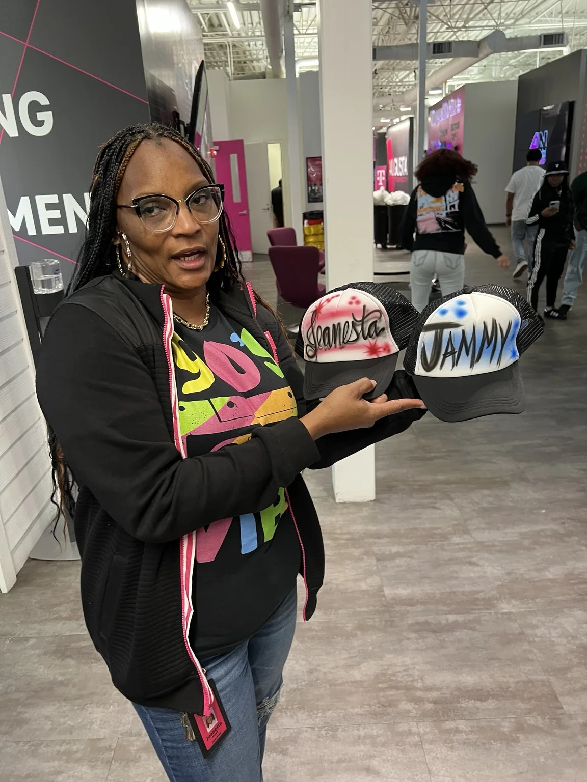 Guest displaying two personalized airbrushed hats at the T-Mobile event in Augusta