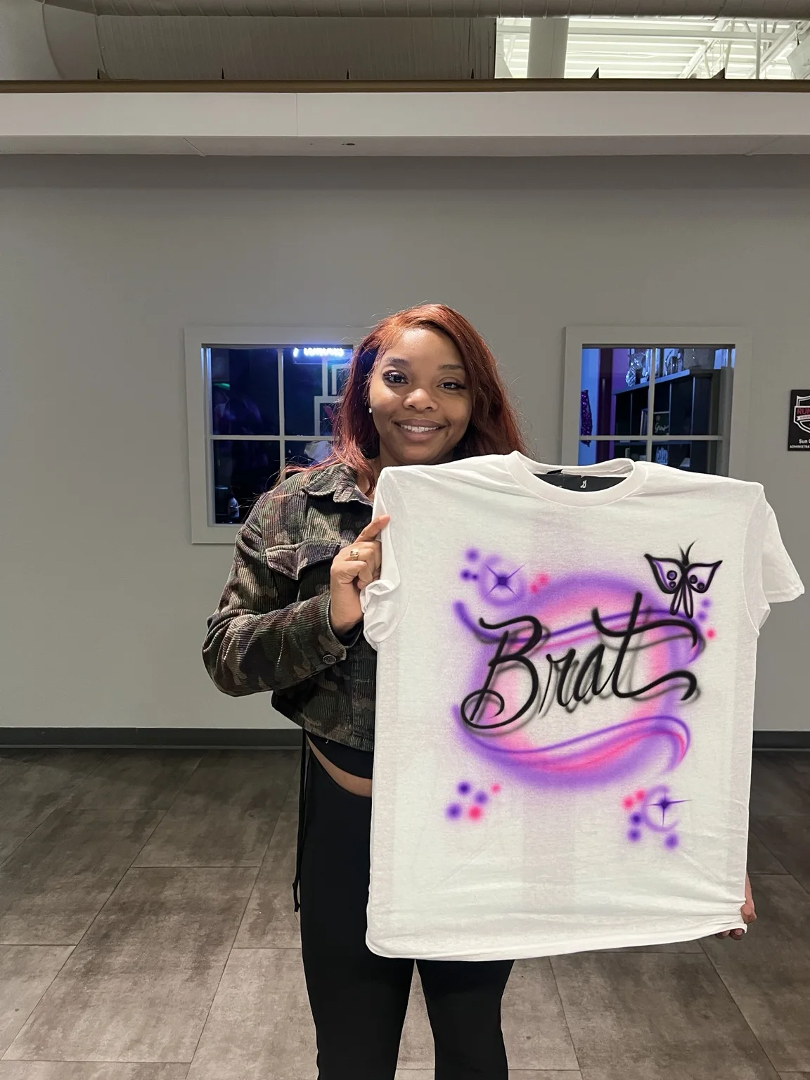 Guest holding a purple custom airbrushed T-shirt at the T-Mobile event in Augusta