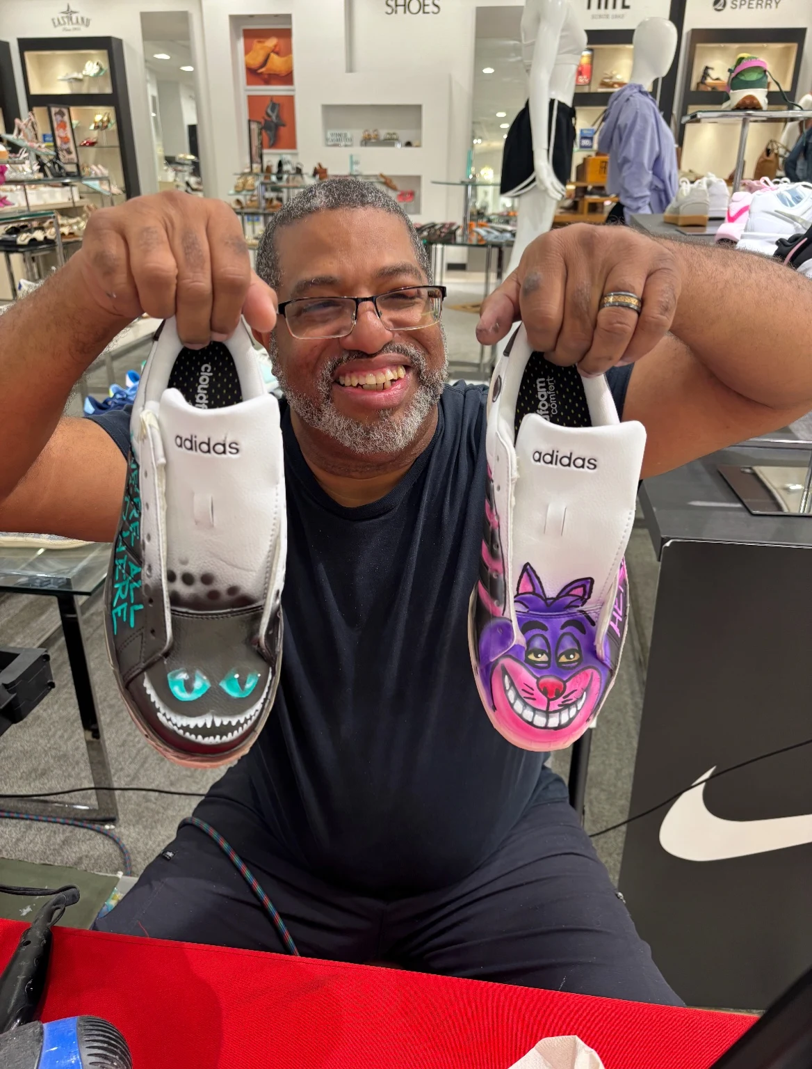 Artist displaying customized sneakers at a Belk event