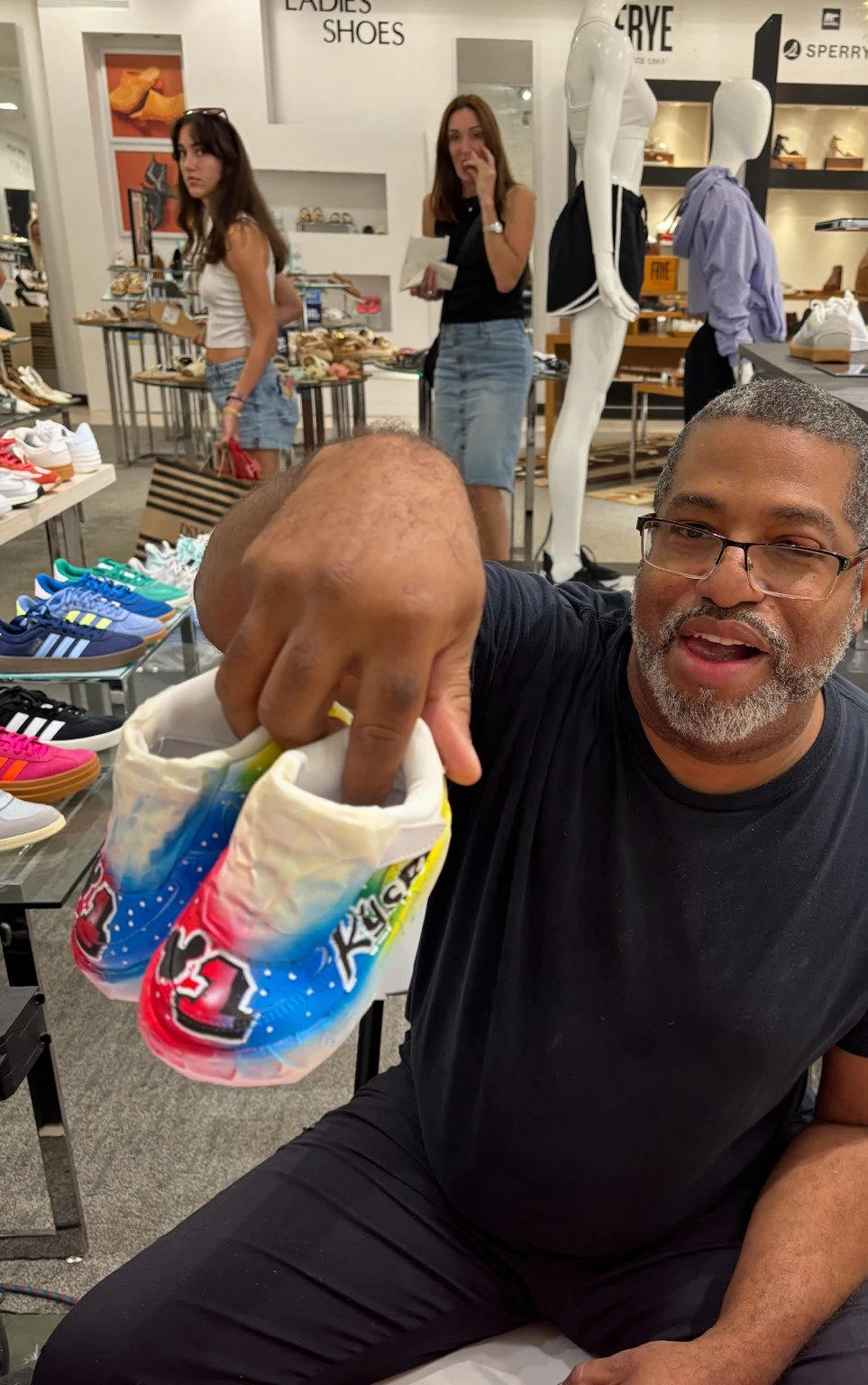 Artist showing colorful customized sneakers at Belk
