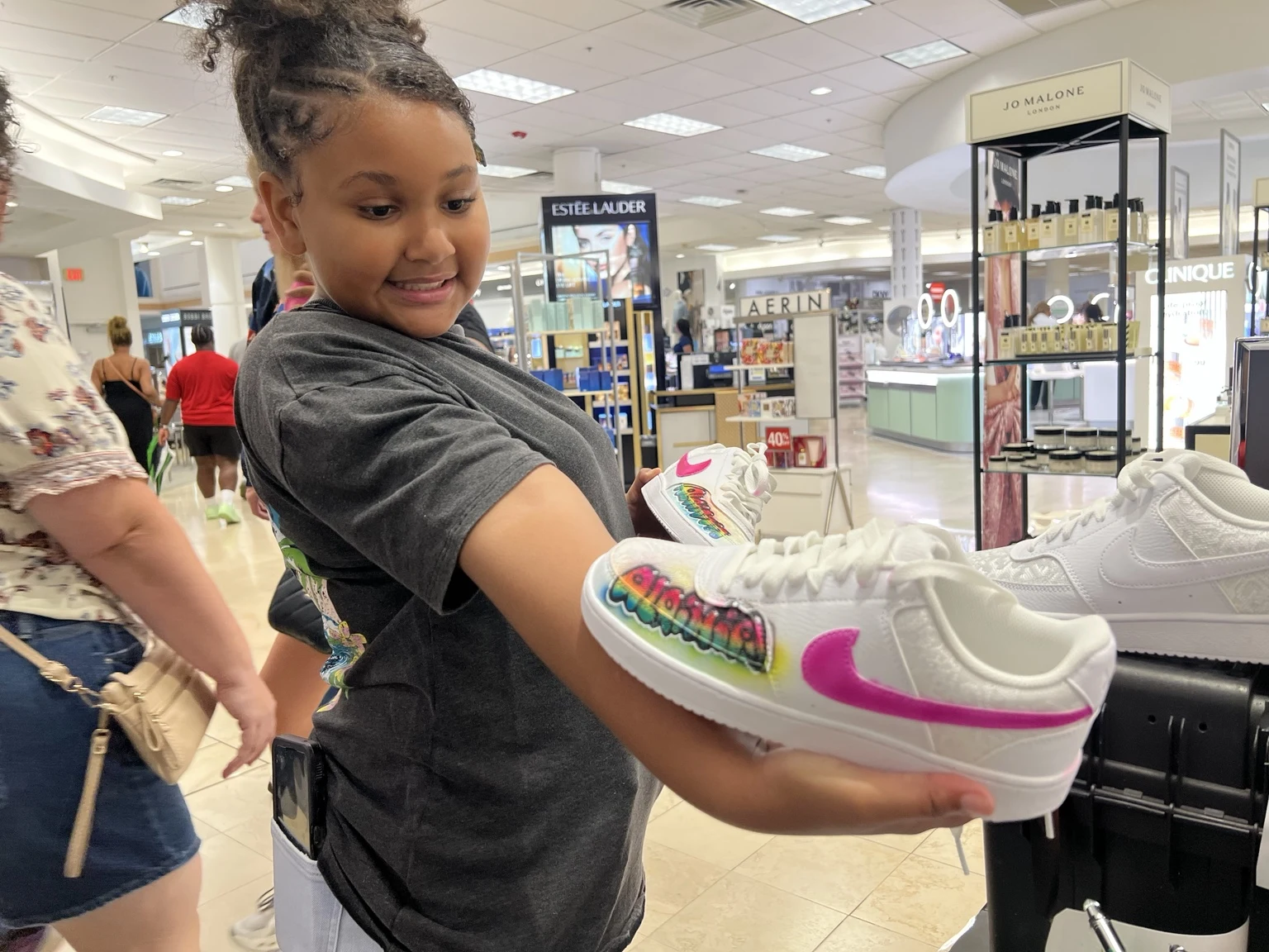 Guest holding a Nike shoe with pink airbrushed accents