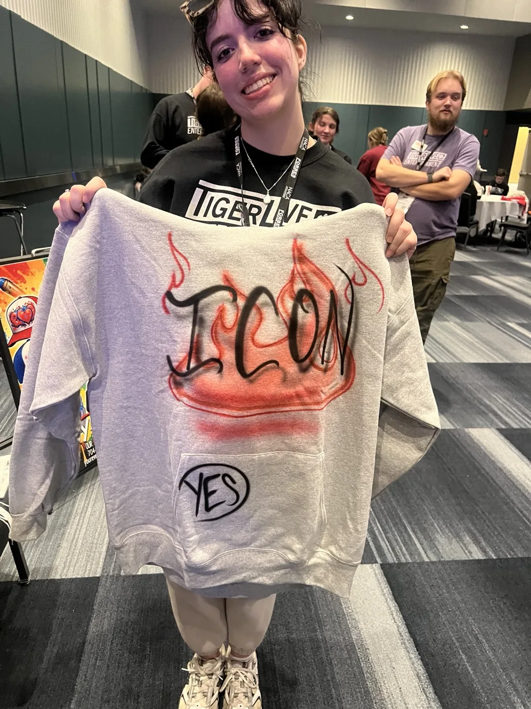 Student holding a colorful custom airbrushed sweatshirt