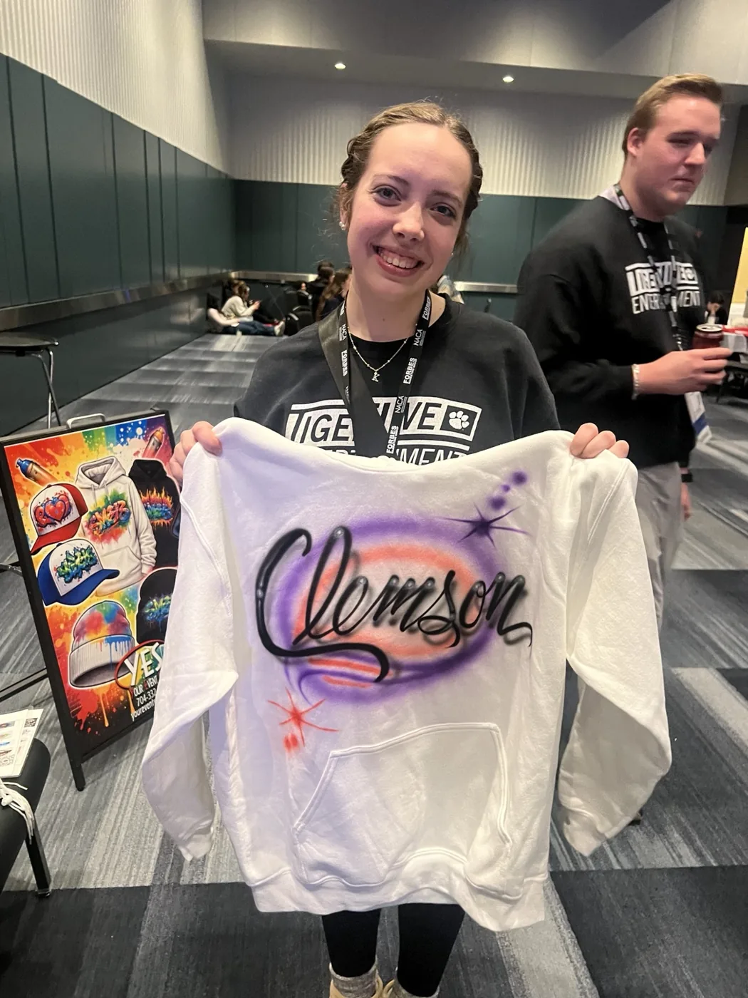 Student holding a personalized airbrushed sweatshirt