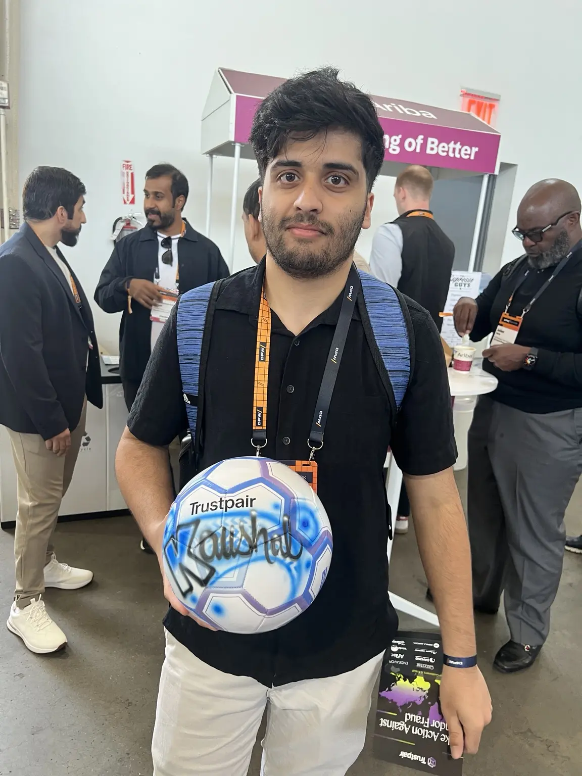 Conference attendee displaying a personalized airbrushed soccer ball in Brooklyn