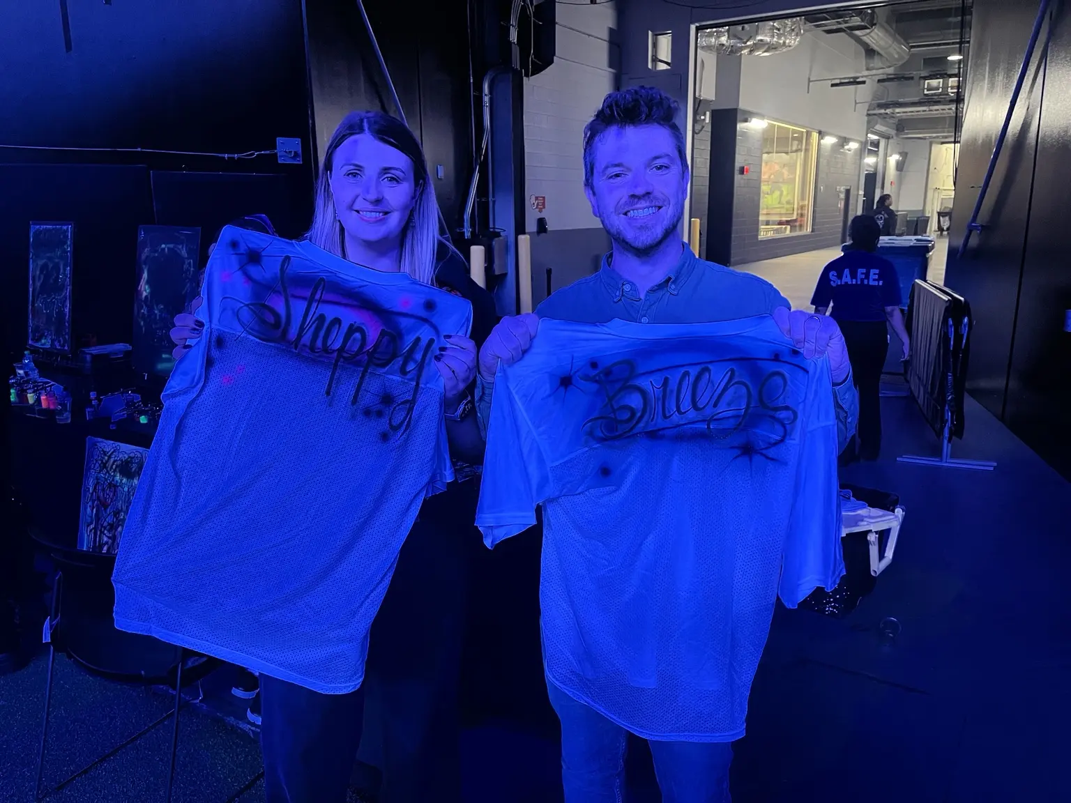 Couple holding custom airbrushed football jerseys at the Atlanta Falcons stadium event