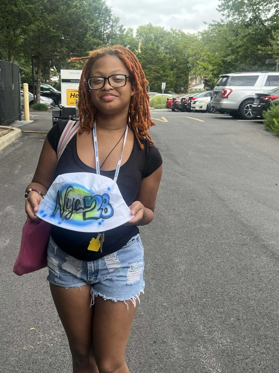 Delaware State University student displaying a custom airbrushed bucket hat