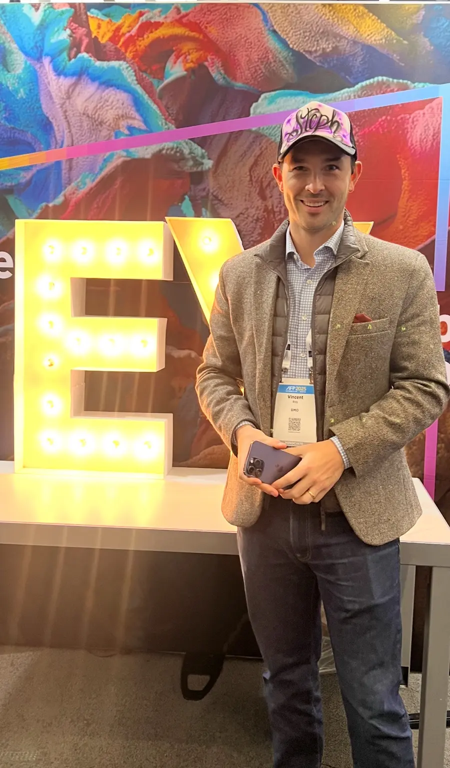 Guest at the EY Boston corporate event standing in front of the branded event display