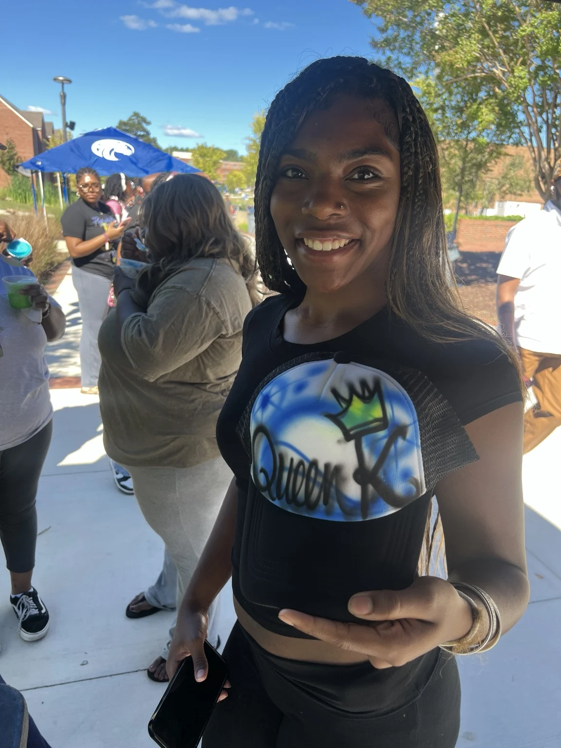 Guest displaying a blue personalized trucker hat at Fayetteville State University homecoming