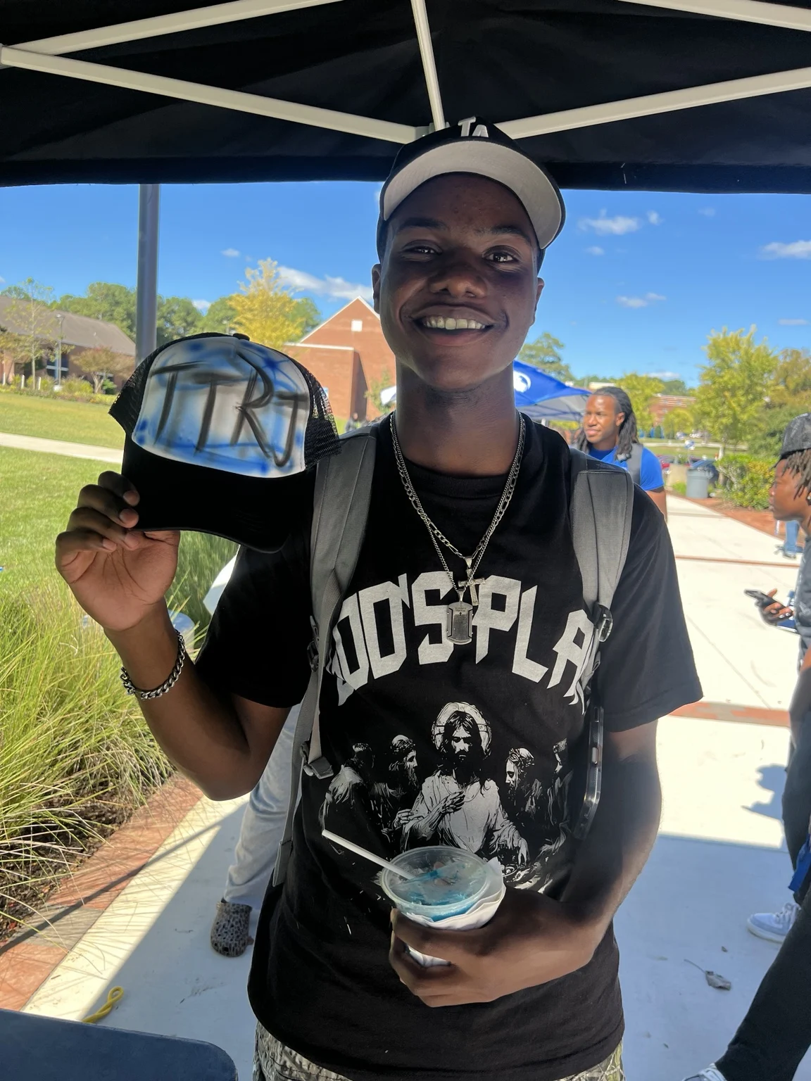 Guest holding a personalized hat at the outdoor activation at Fayetteville State University homecoming