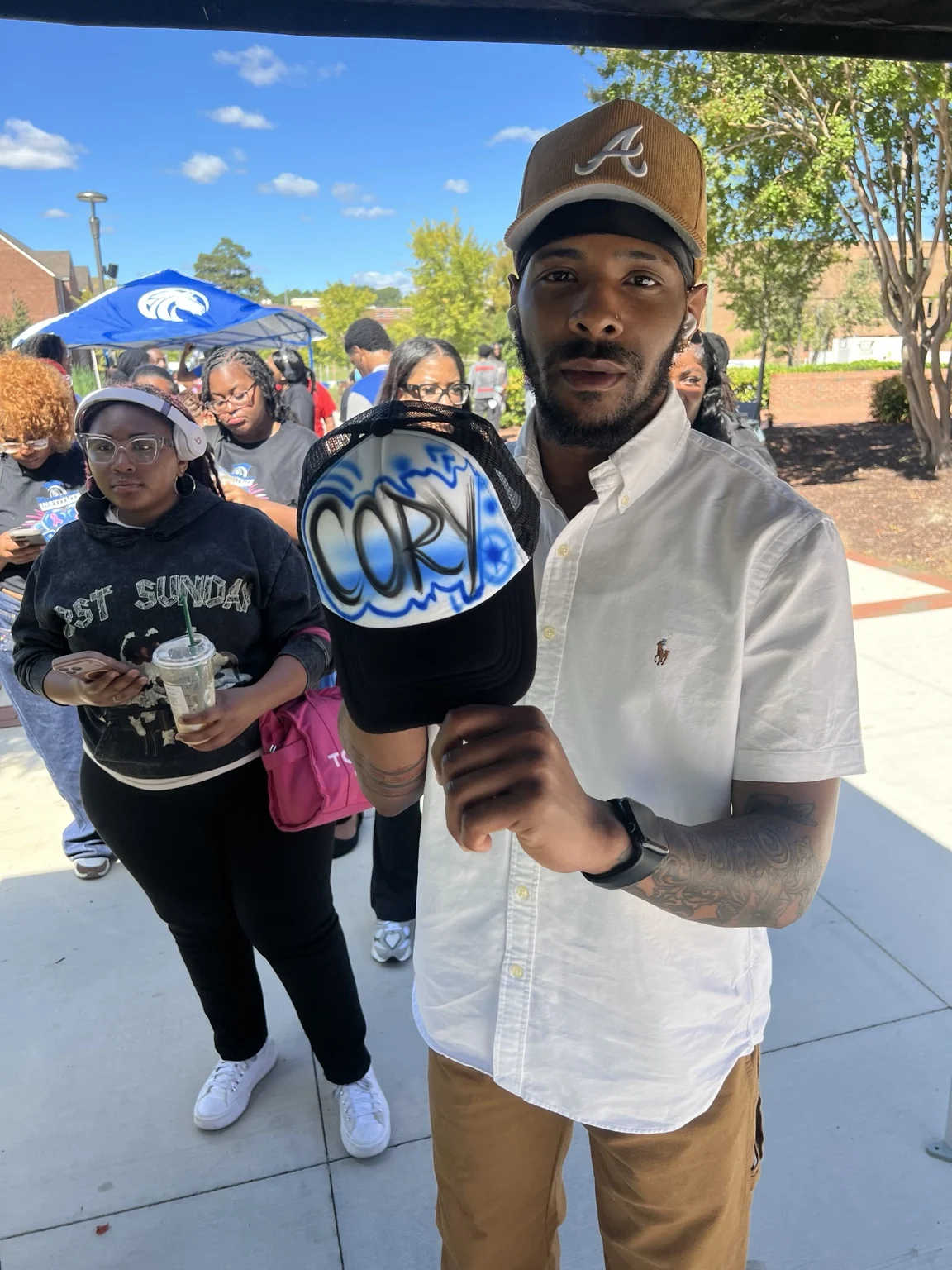Guest showing a blue personalized trucker hat at Fayetteville State University homecoming