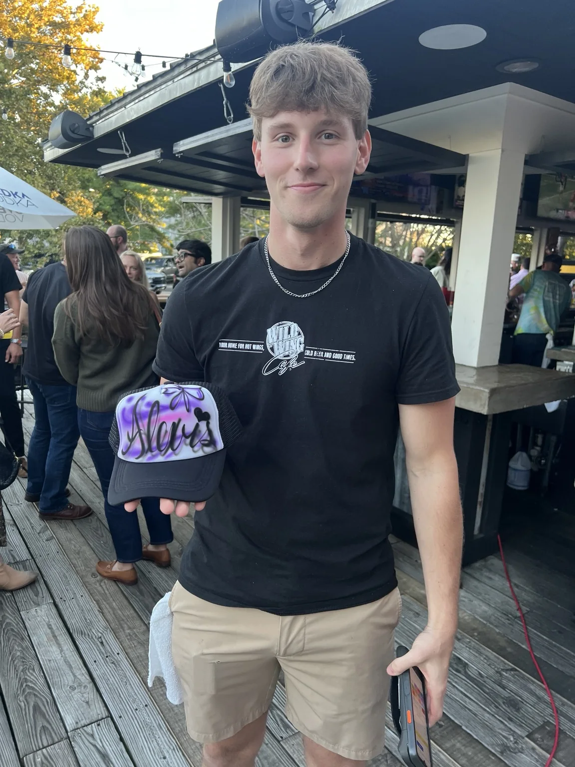 Guest holding a purple personalized airbrushed trucker hat at a Knoxville reunion