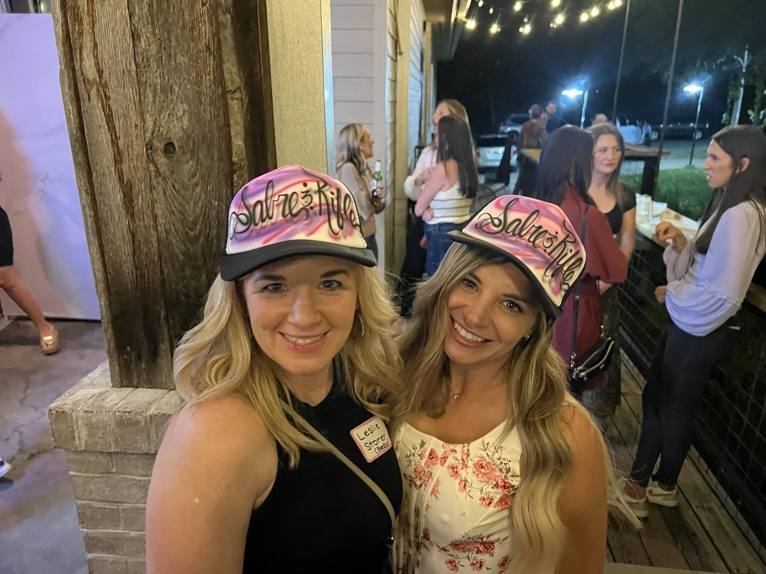 Two Knoxville class reunion guests wearing personalized airbrushed trucker hats