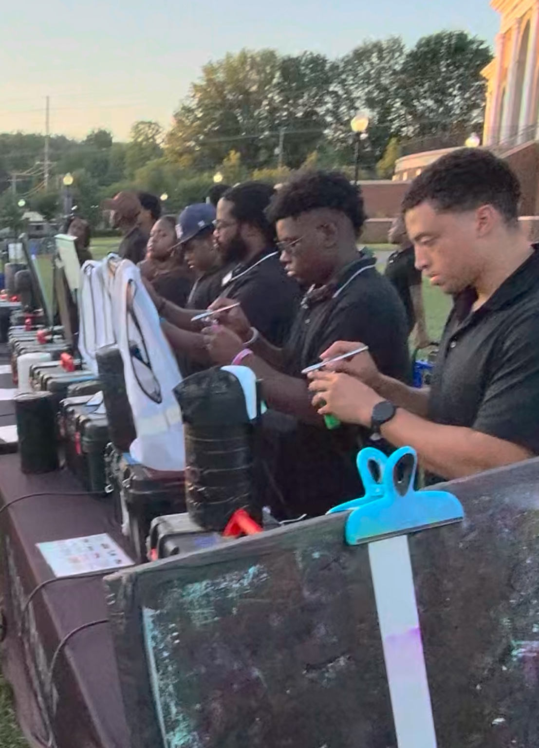3JS airbrush artists working simultaneously along a row of outdoor event workstations