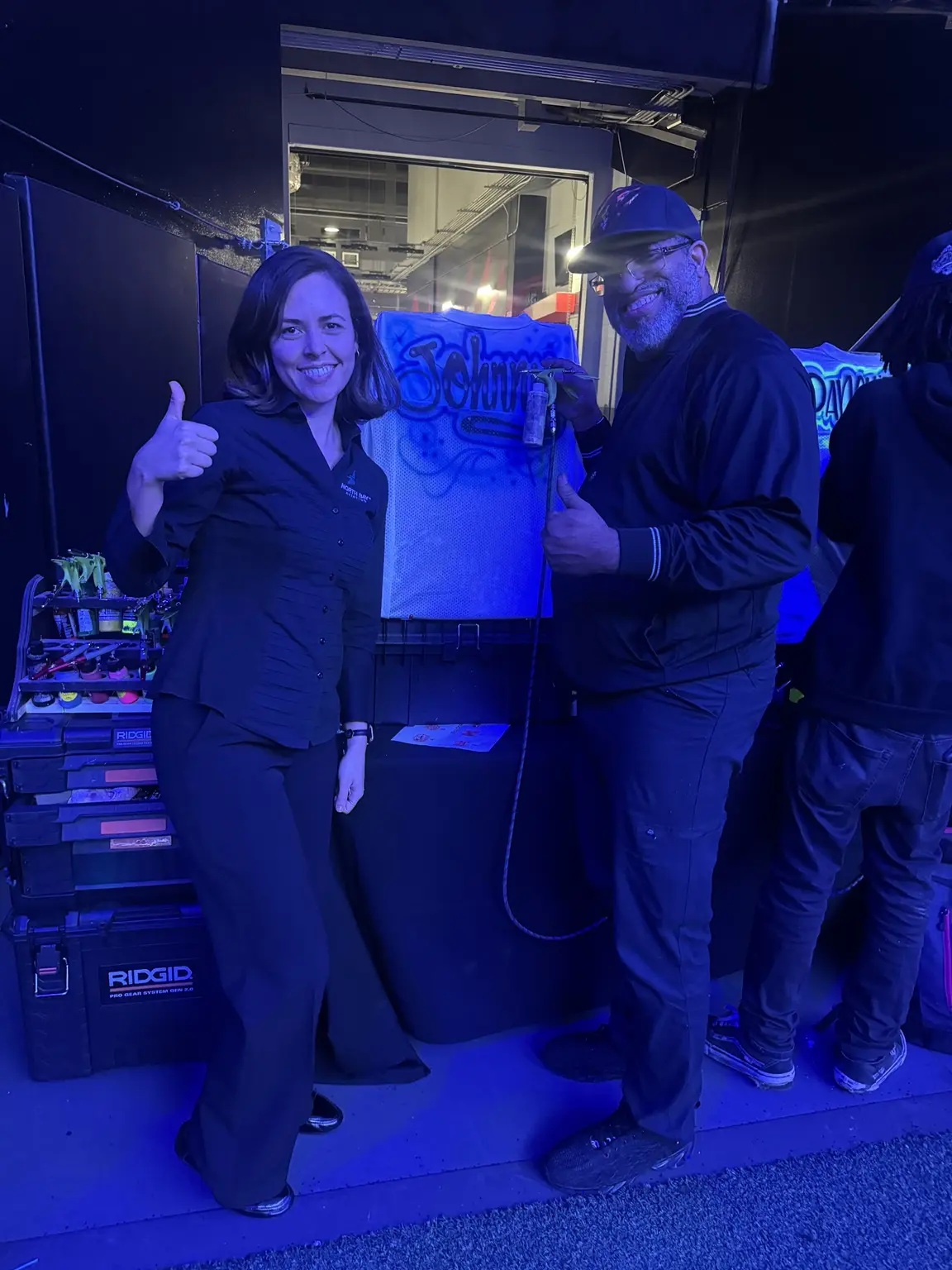 Guest giving a thumbs up while holding a custom airbrushed football jersey