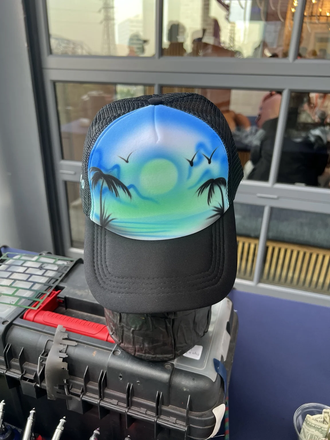 Tropical sunset and palm trees airbrushed on a trucker hat in Nashville, Tennessee