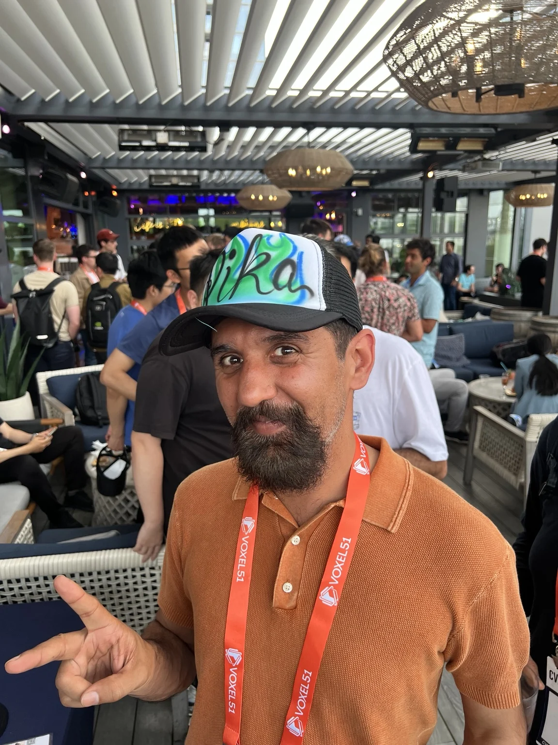 Corporate guest showing green and blue airbrushed lettering on a hat in Nashville, Tennessee