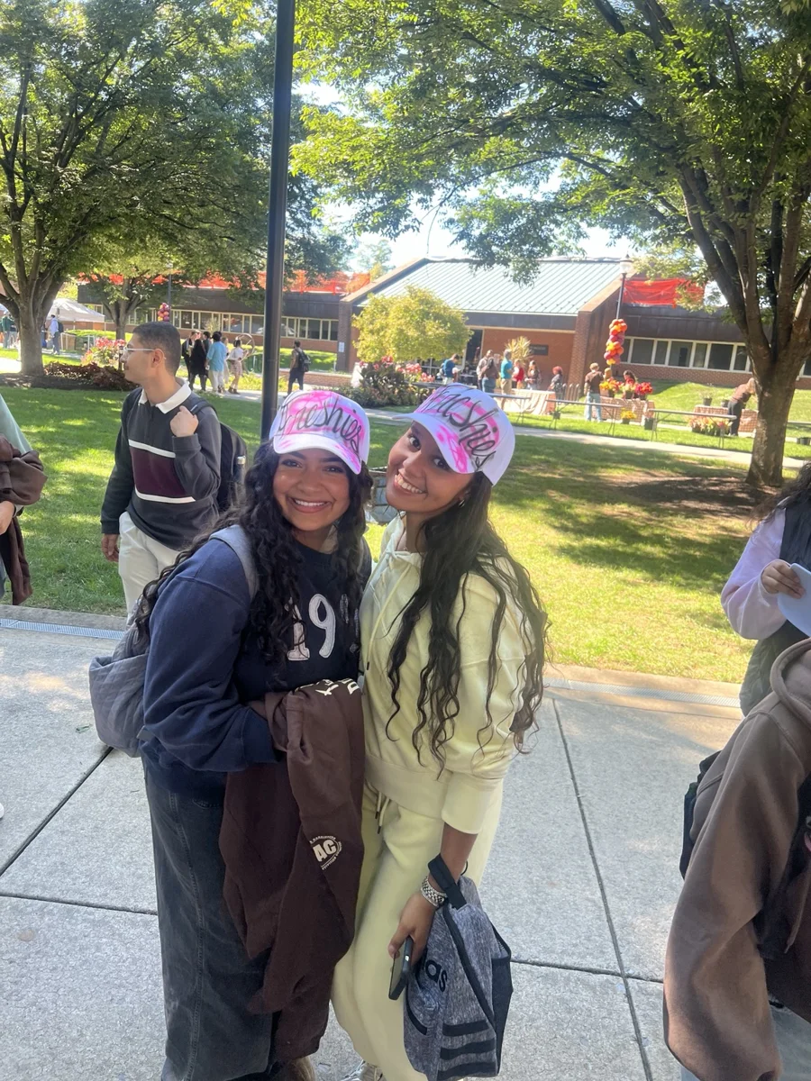 Two guests wearing pink personalized baseball hats at the campus activation