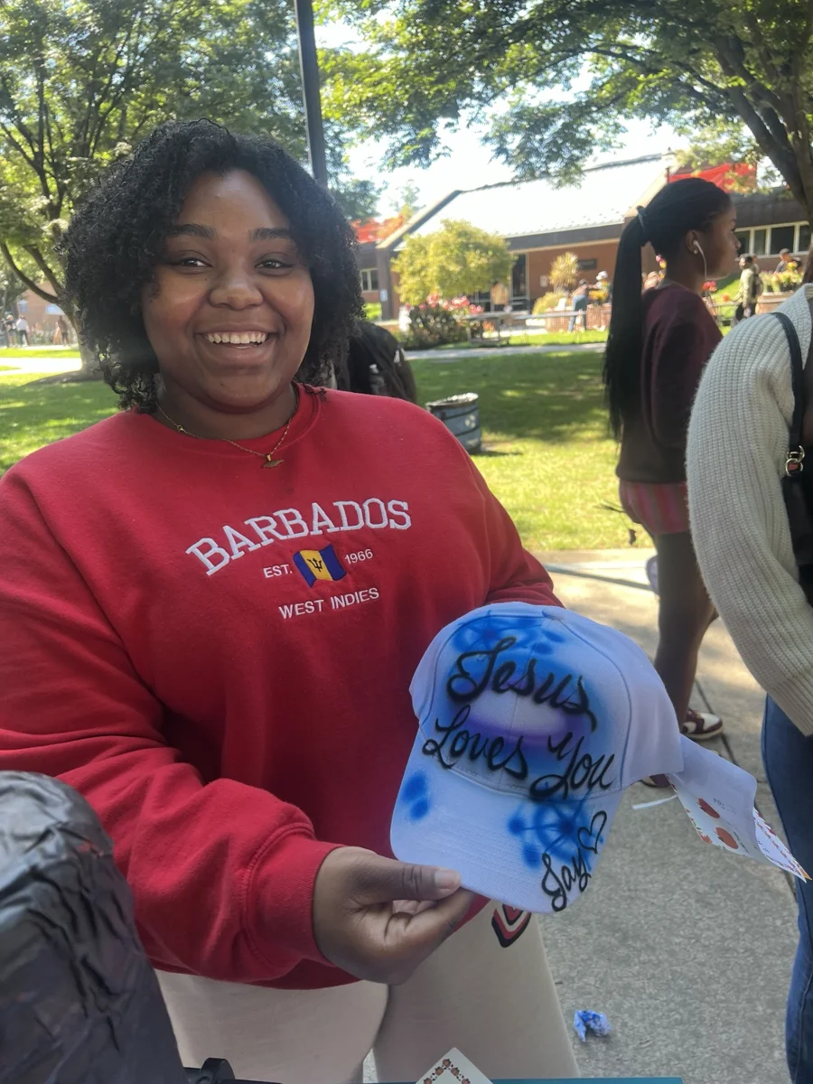 Guest displaying a blue baseball hat with decorative airbrushed lettering