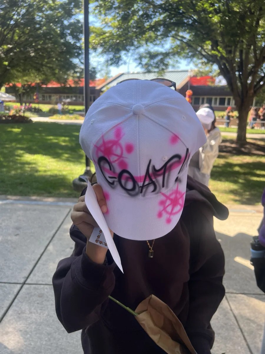 Close view of pink flowers and lettering on a custom airbrushed baseball hat