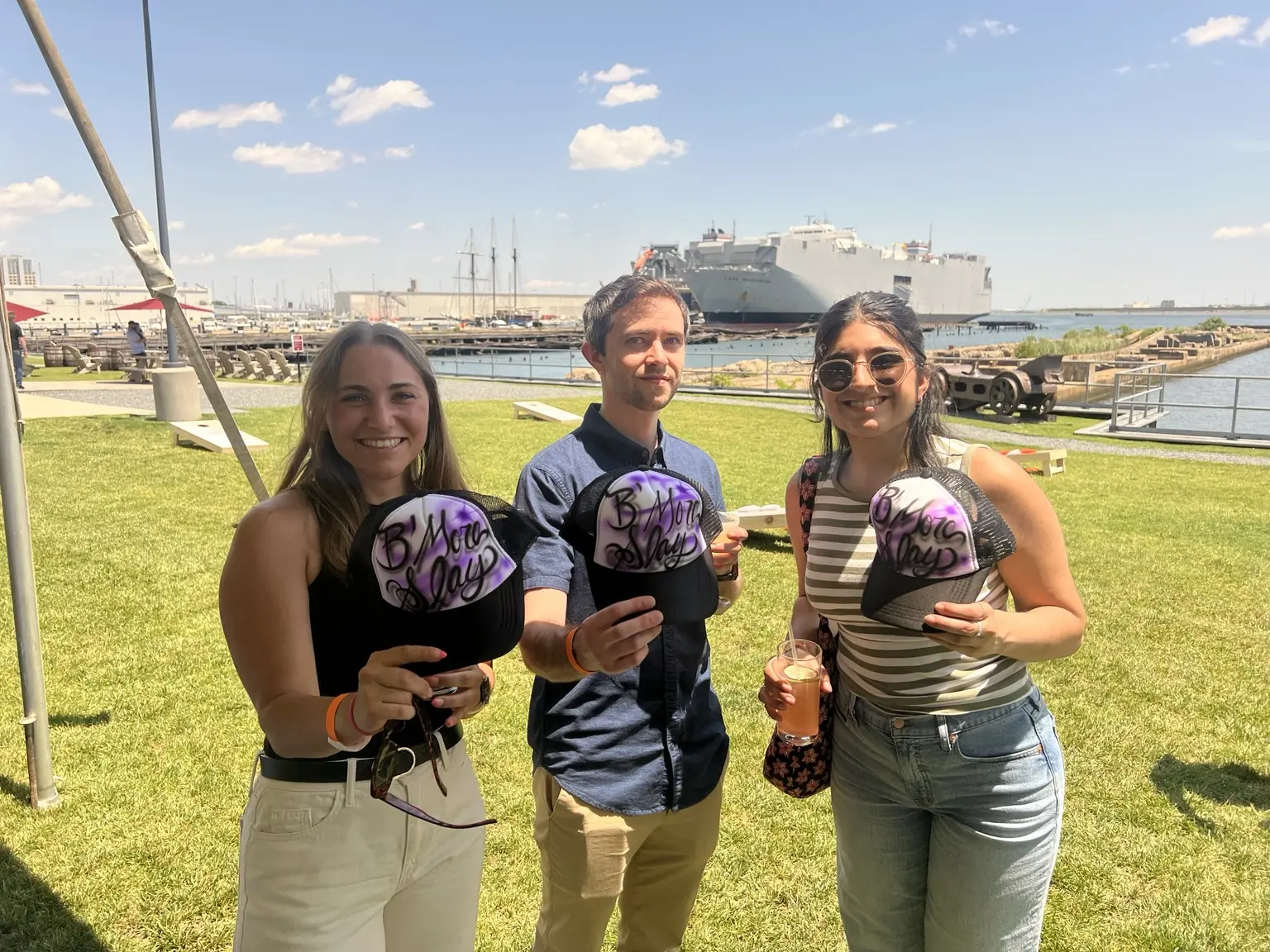 PwC corporate event guests displaying personalized airbrushed trucker hats on the Baltimore waterfront