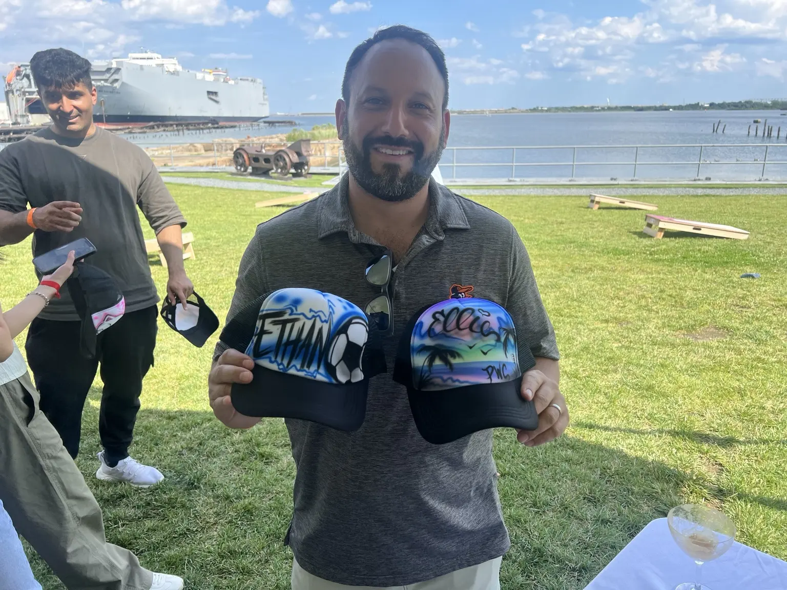 PwC guest holding two blue personalized airbrushed hats