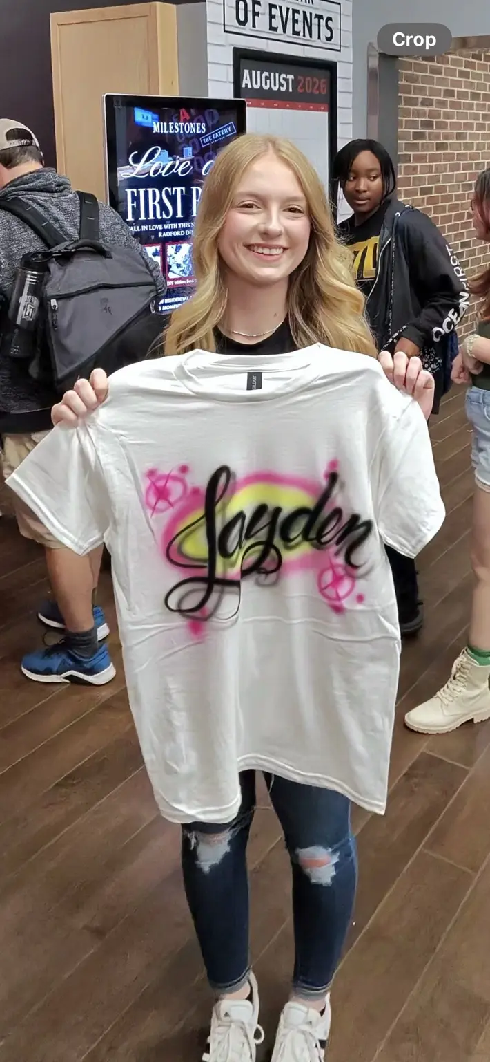 Radford University student holding a colorful personalized airbrushed T-shirt