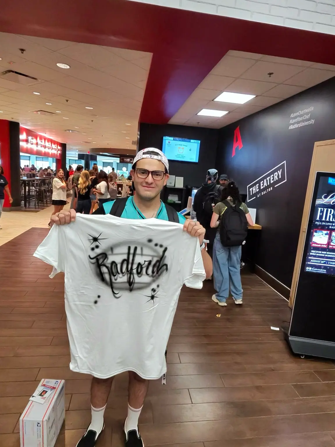 Radford University guest holding a black and white custom name airbrushed T-shirt
