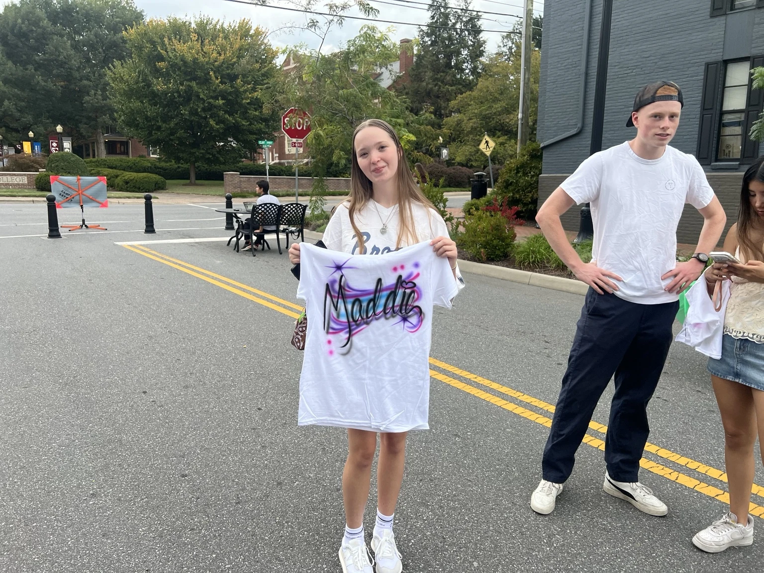 Students displaying personalized airbrushed shirts at Roanoke College Fall Festival in Salem, Virginia