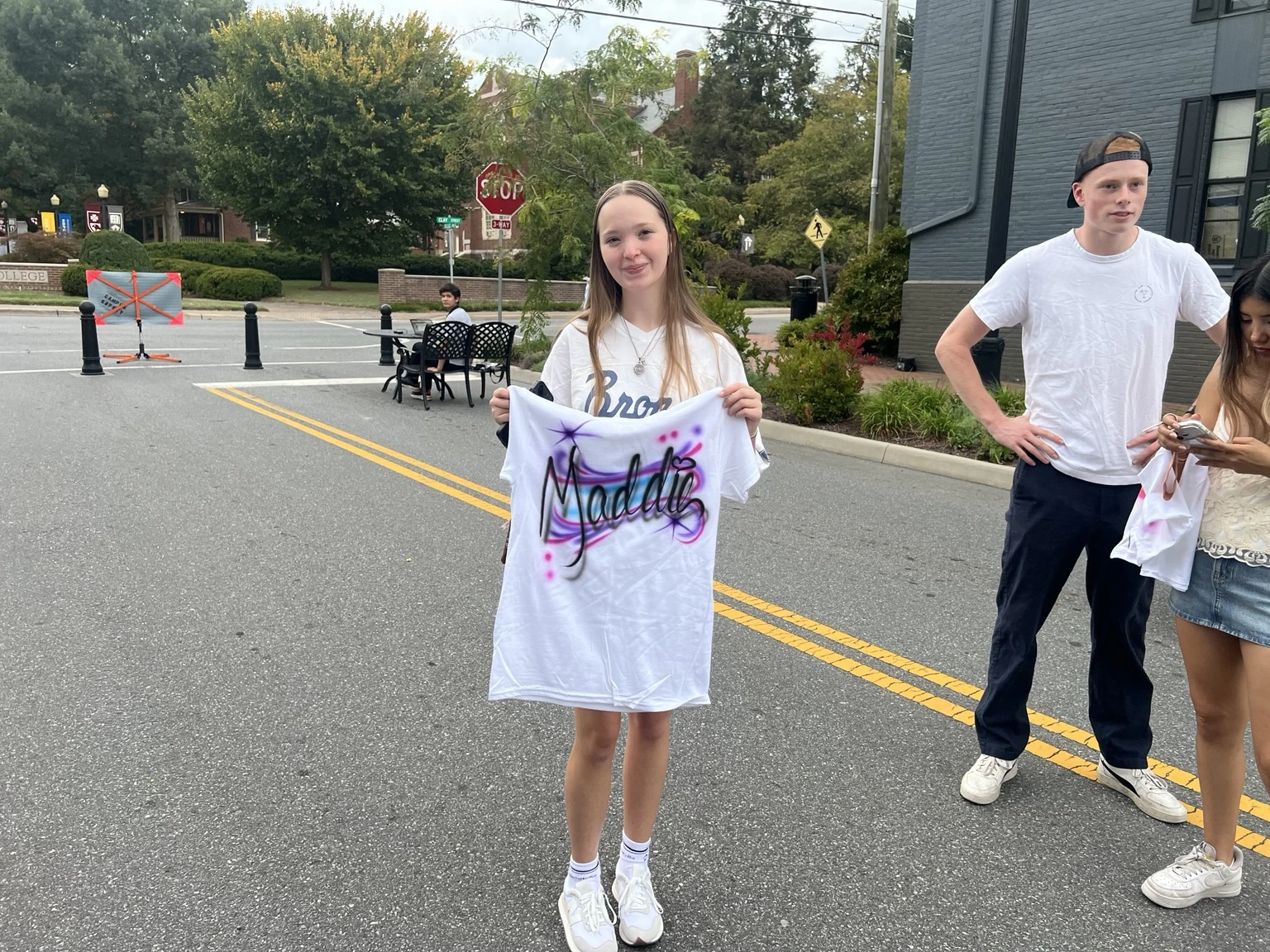 Students displaying personalized airbrushed shirts at Roanoke College Fall Festival in Salem, Virginia