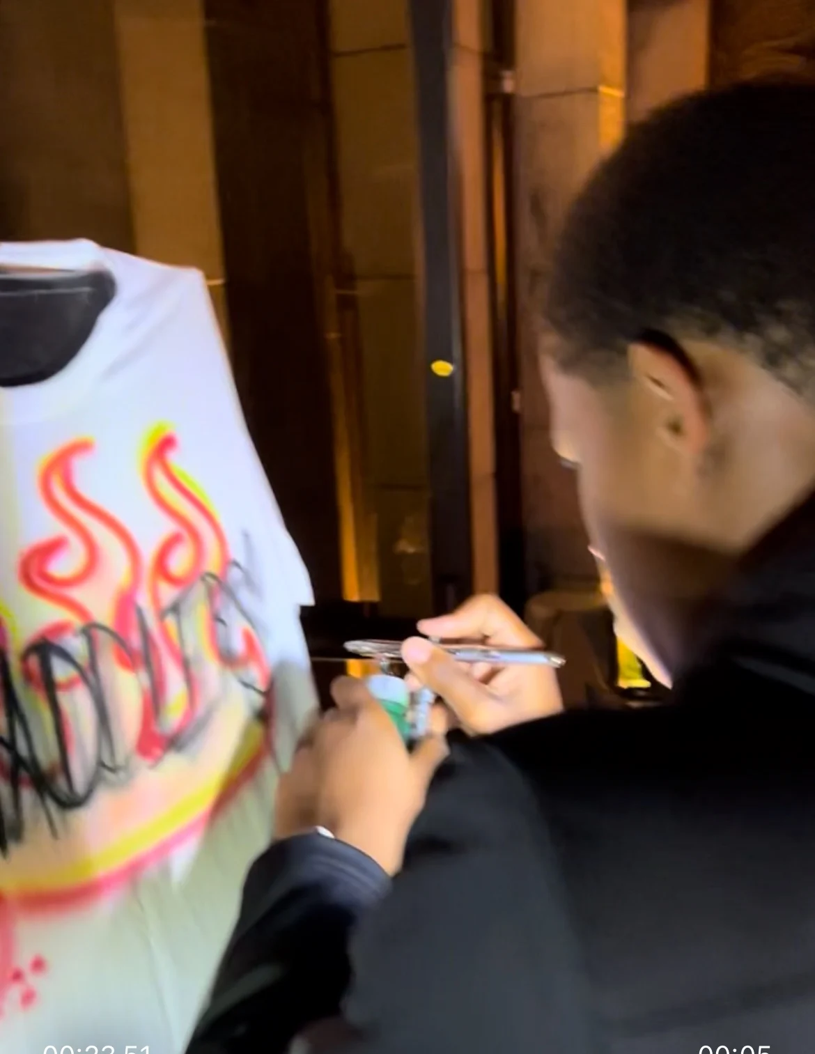 Artist painting a flame design on a white T-shirt