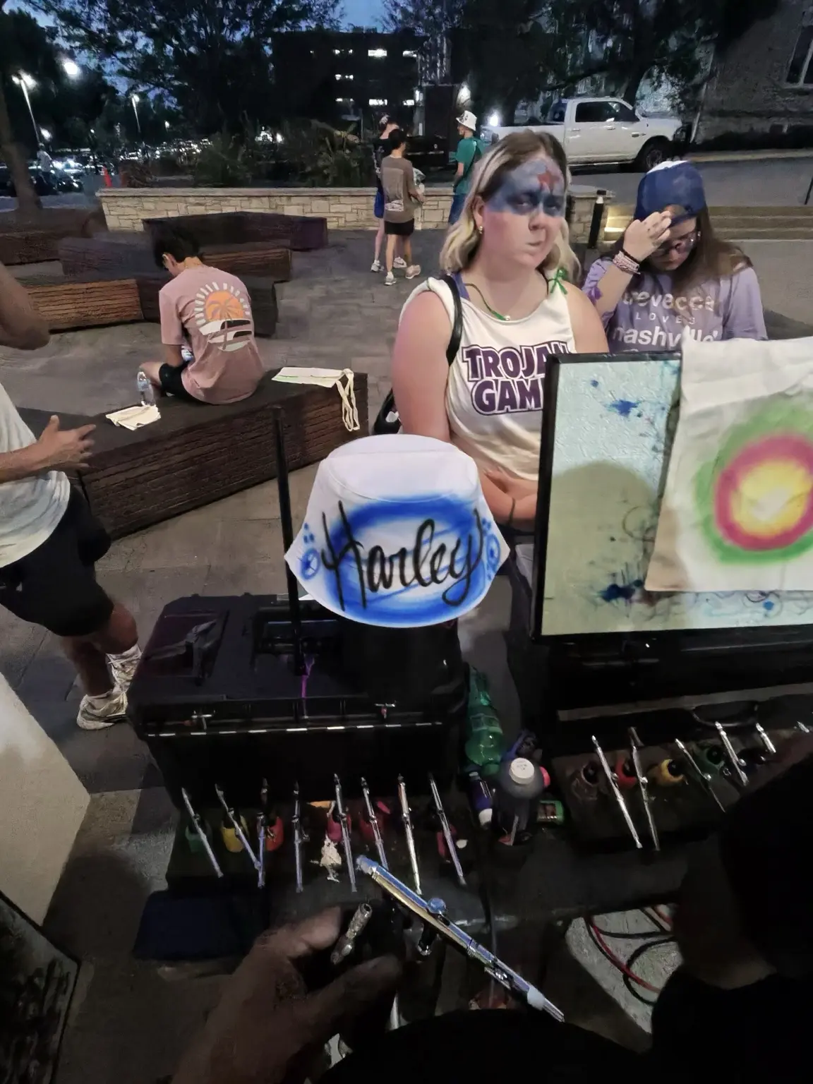 Live airbrush artist station with custom bucket hat and professional equipment at Trevecca Nazarene University