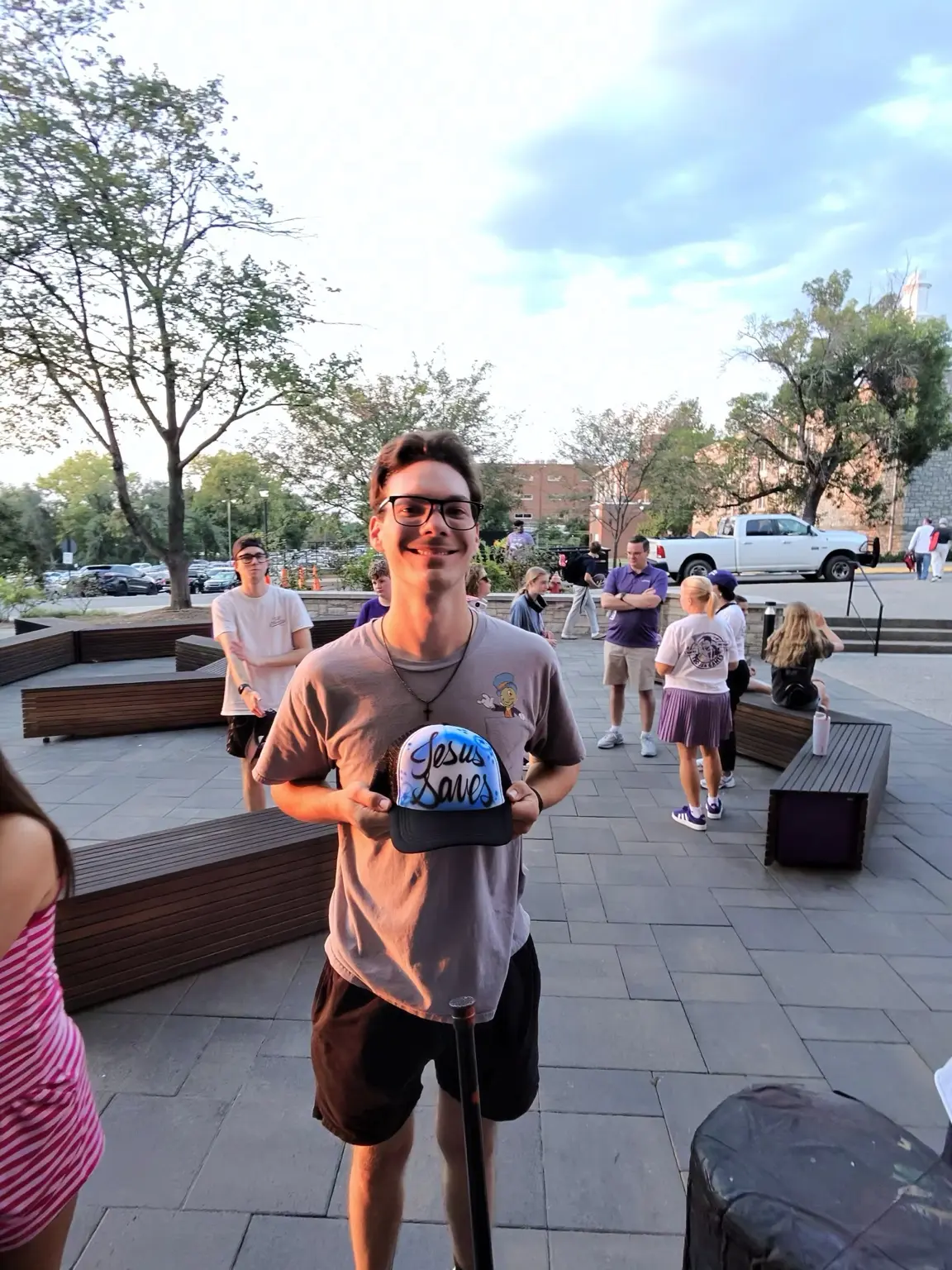 Trevecca Nazarene University student holding a custom Jesus Saves airbrushed bucket hat in Nashville