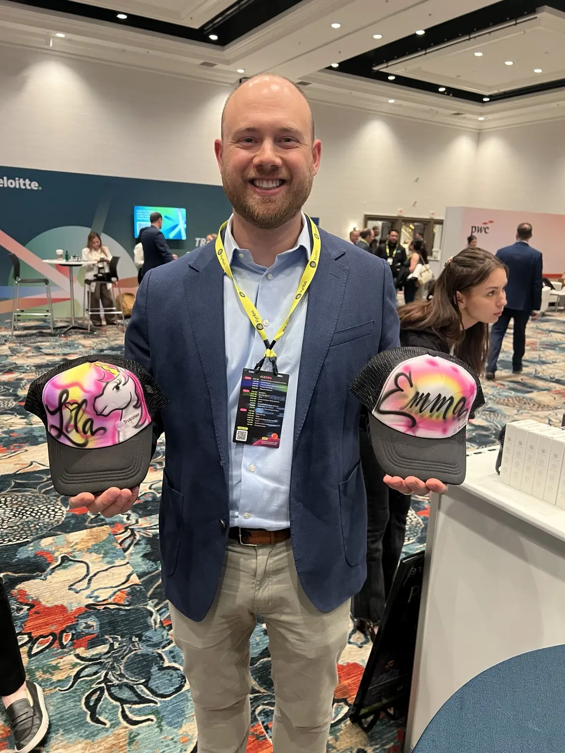 Trustpair conference guest displaying two personalized airbrushed hats
