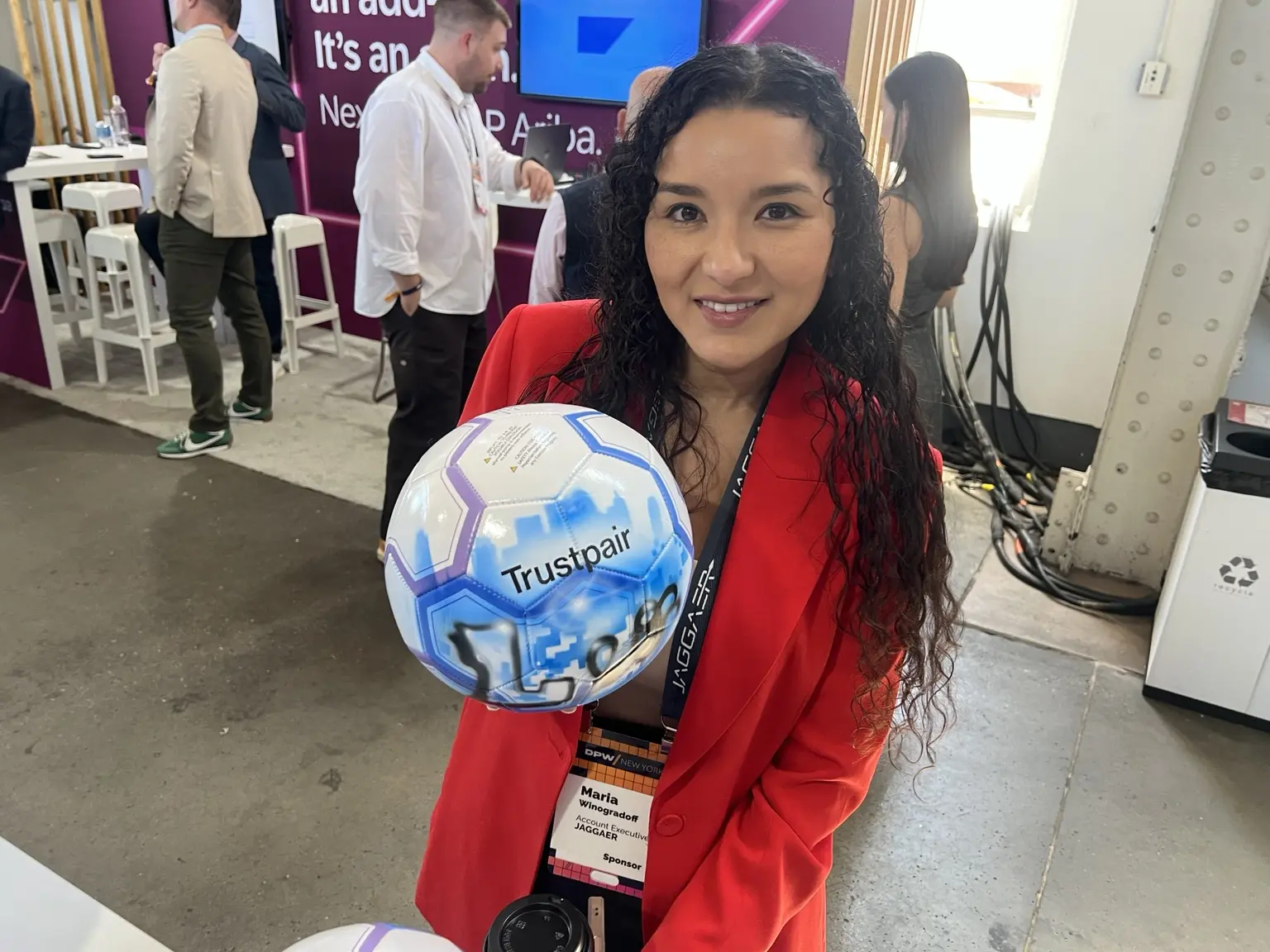 Guest holding a blue Trustpair branded custom soccer ball