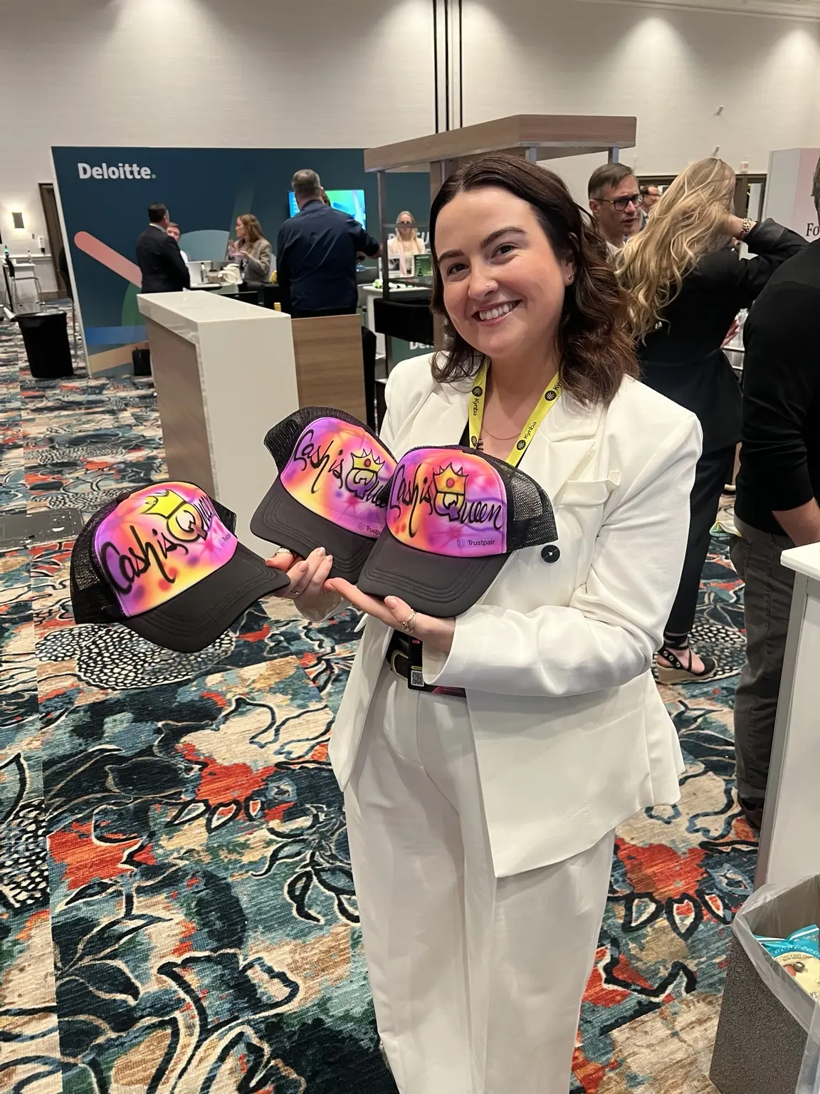 Trustpair event guest displaying colorful custom airbrushed hats in Las Vegas