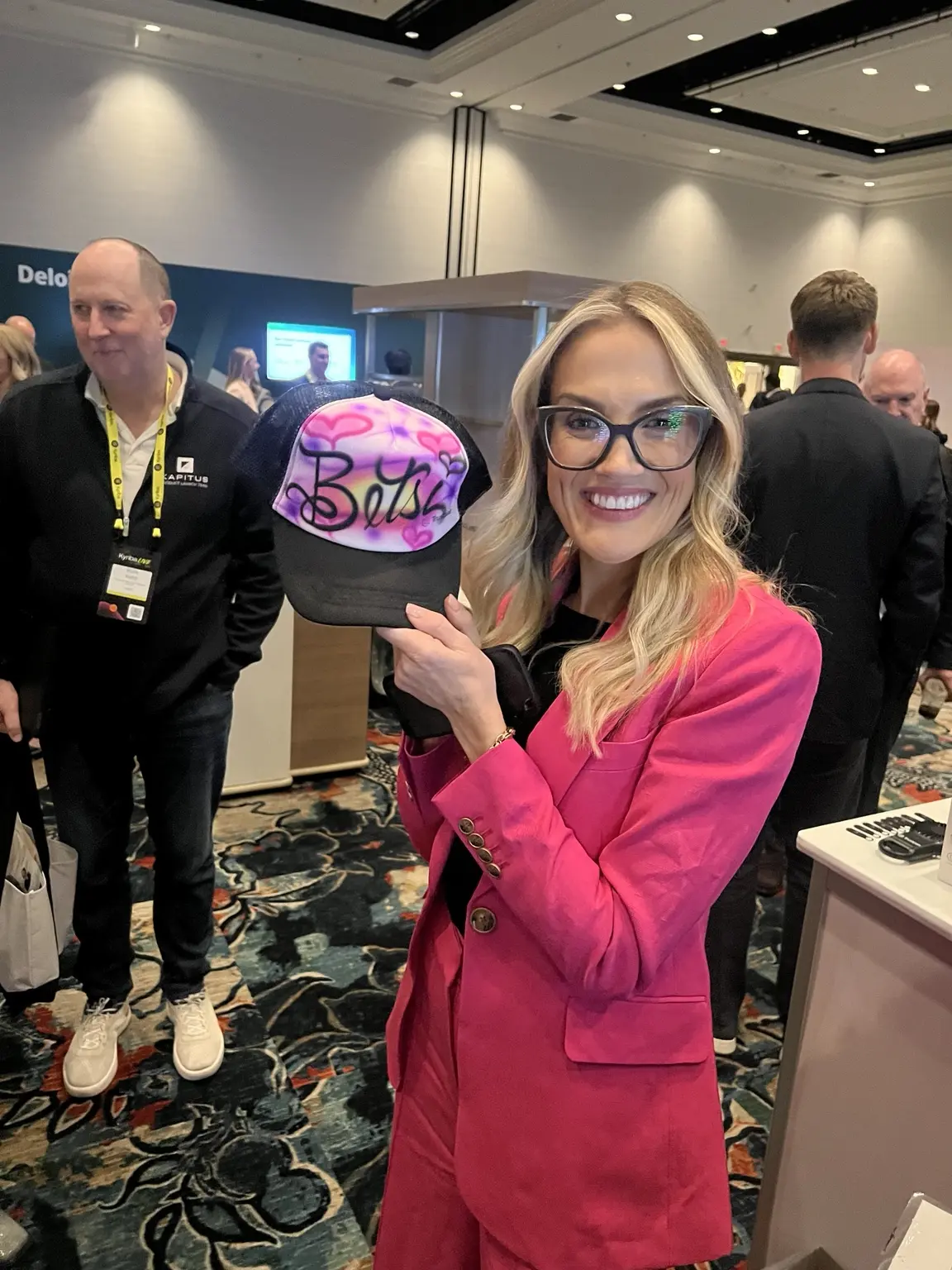 Guest holding a pink personalized airbrushed hat at the Trustpair Las Vegas event