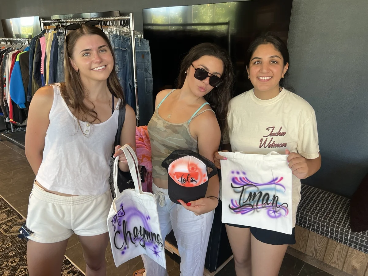 Guests display personalized tote bags and a trucker hat at a University of Tennessee event in Knoxville.