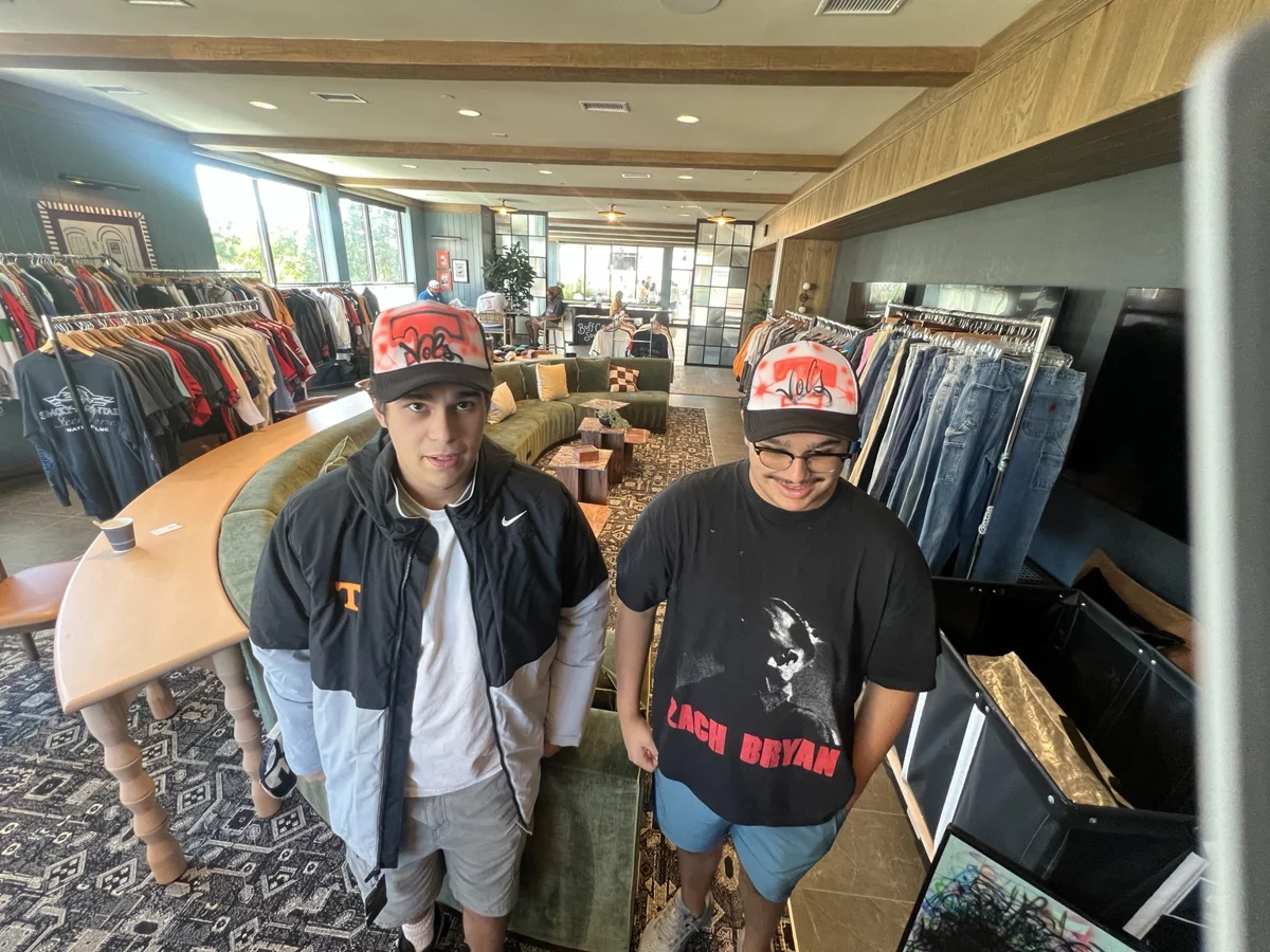 Two guests wearing Tennessee inspired airbrush trucker hats at the Knoxville college event.
