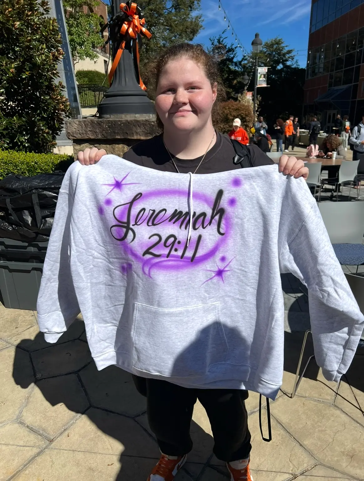 University of Pikeville student holding a Jeremiah 29 11 custom airbrushed hoodie