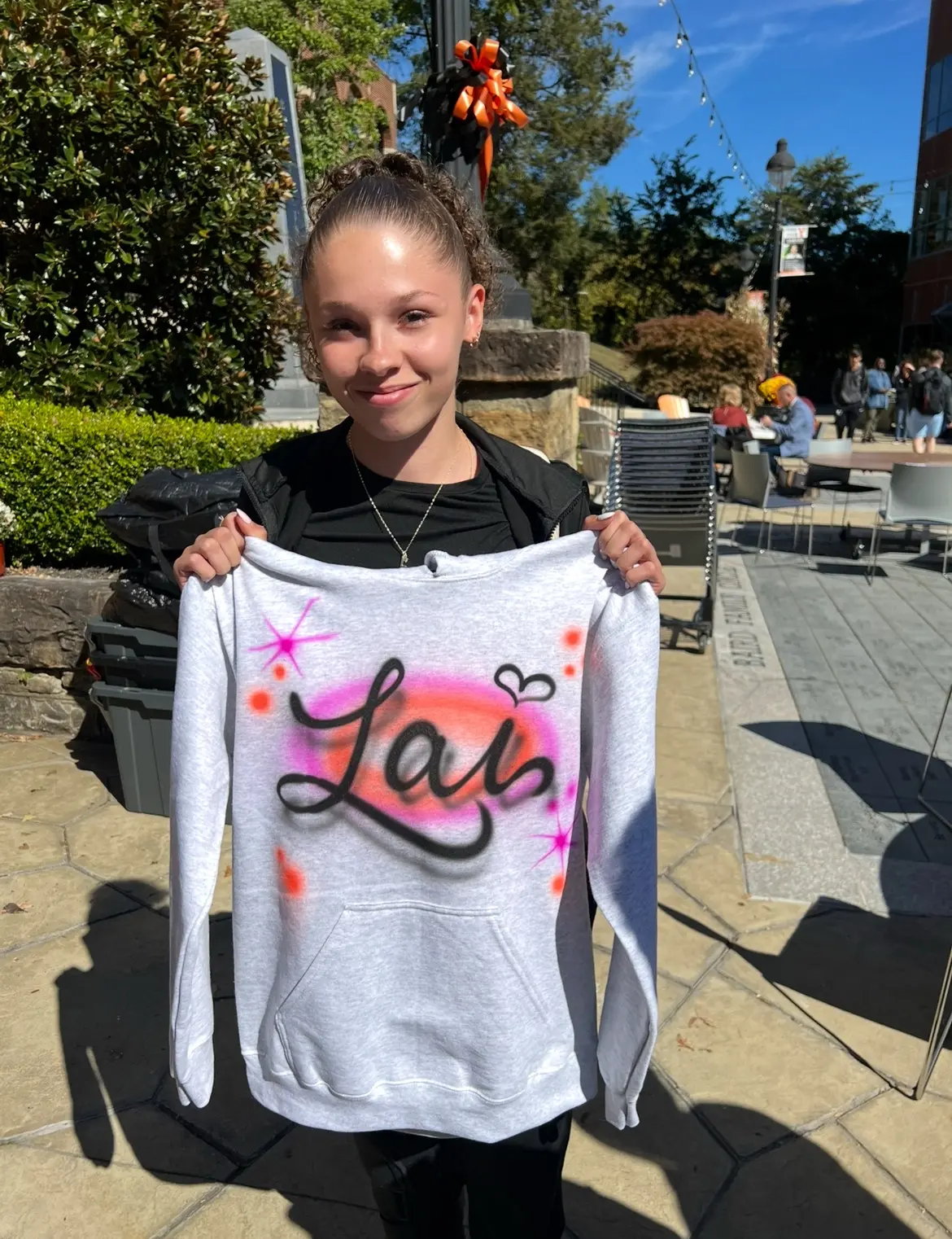 UPIKE student displaying a personalized Lala airbrushed hoodie