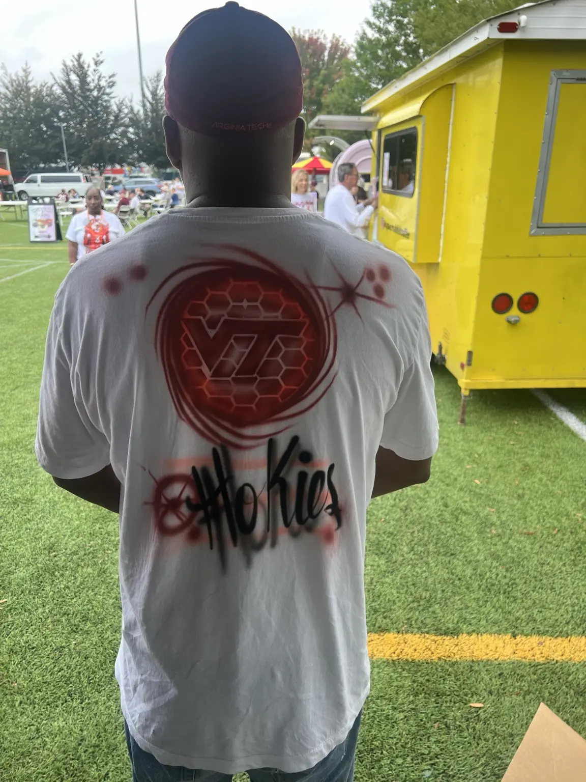 Guest displaying a custom airbrushed shirt from a Virginia Tech event