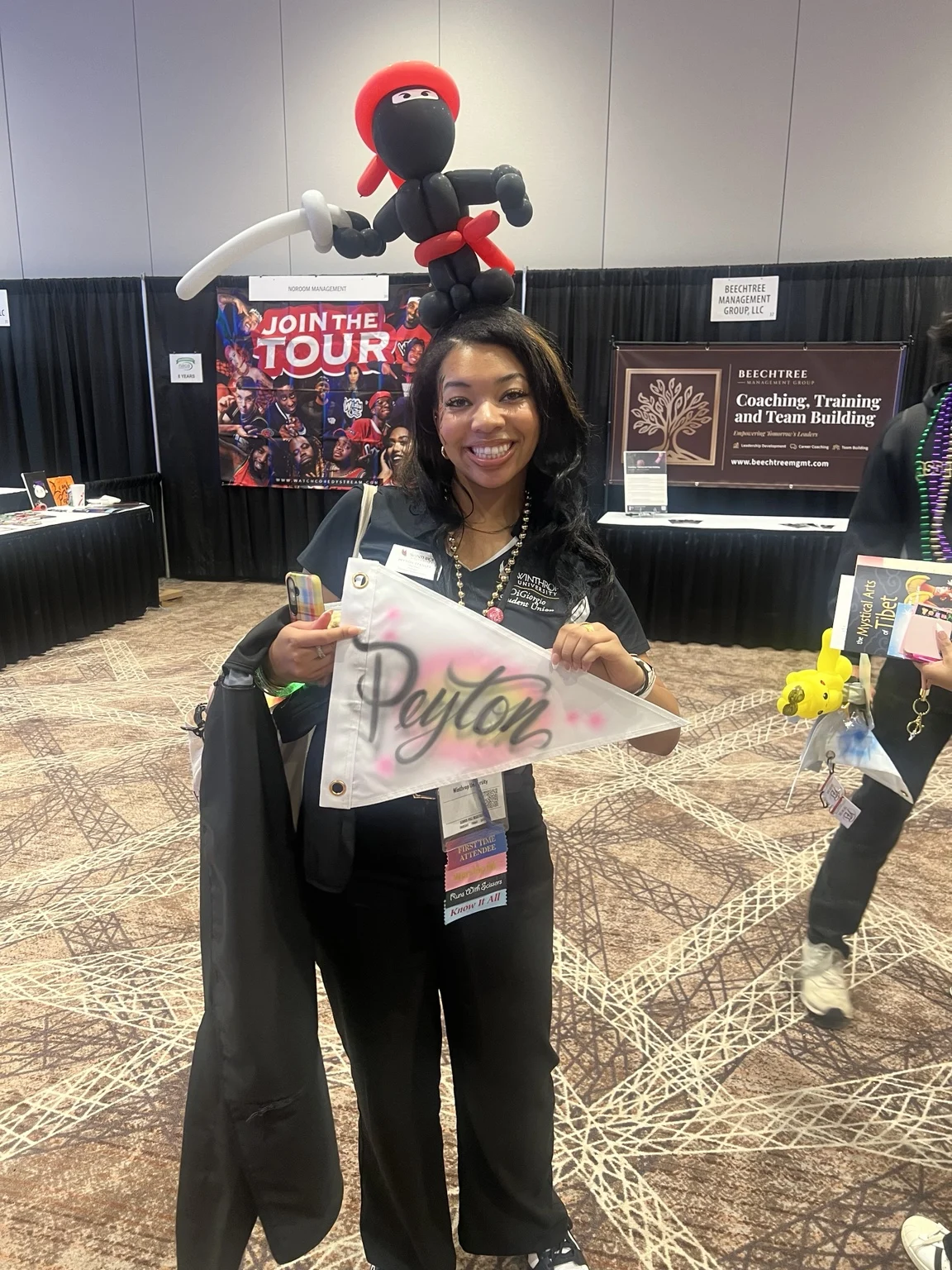 Winthrop University student holding a personalized pink airbrushed name pennant
