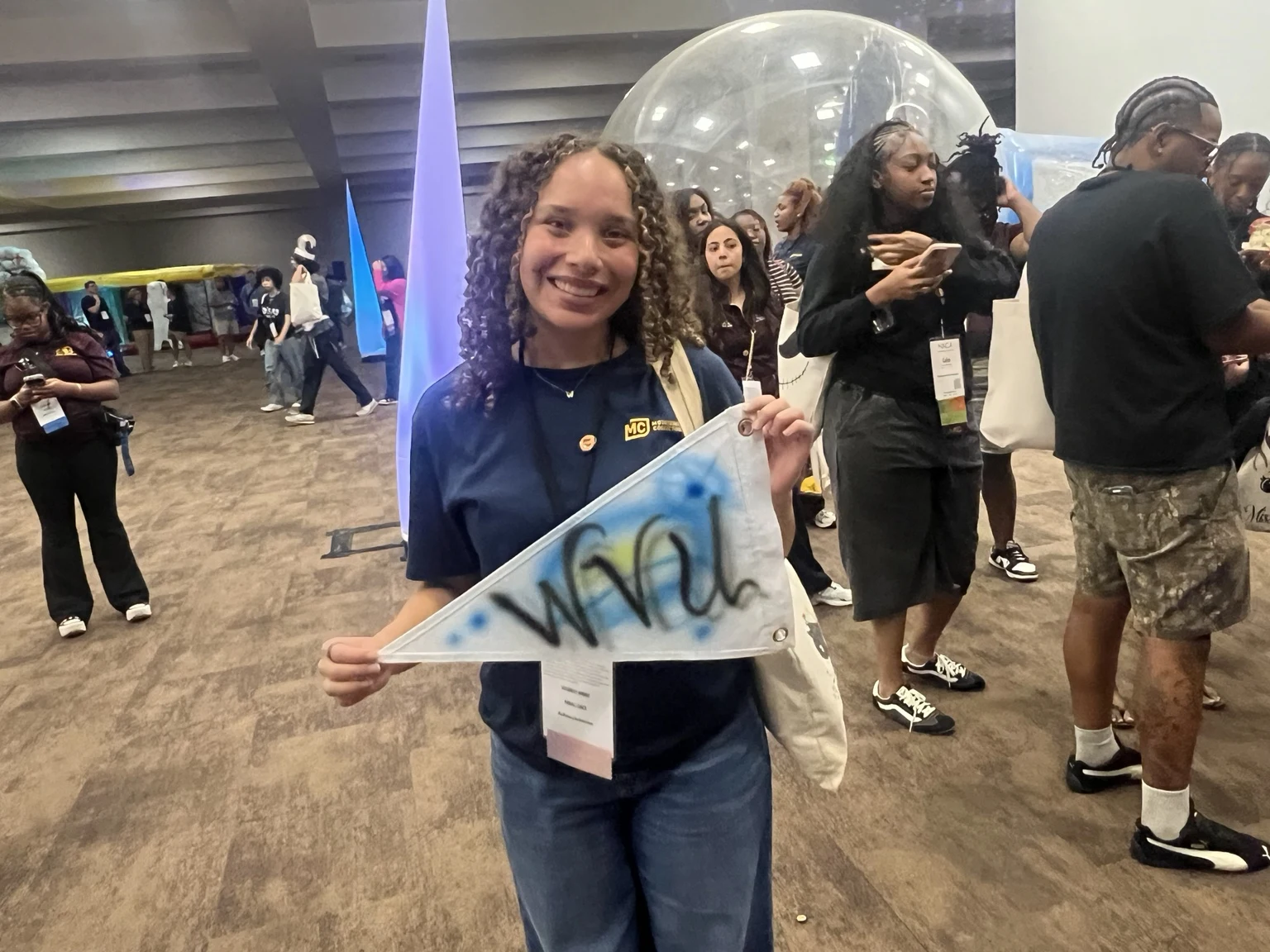 West Virginia University student displaying a personalized airbrushed team pennant with blue and yellow accents, photo 2